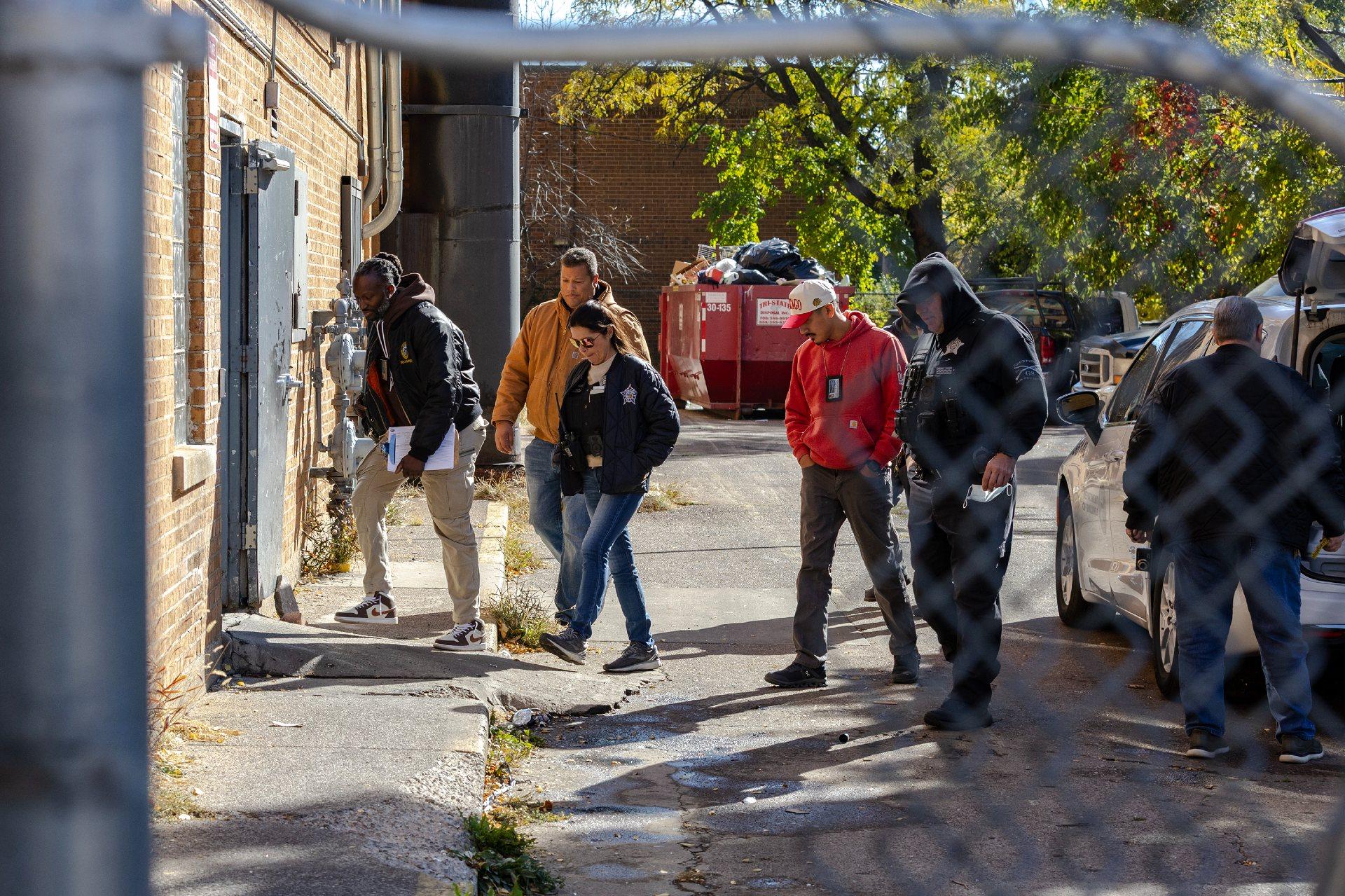 Chicago city employees and the building’s property manager, Corey Oliver, second from left, during an inspection of the apartment complex on Nov. 6. (Jim Vondruska for ProPublica)