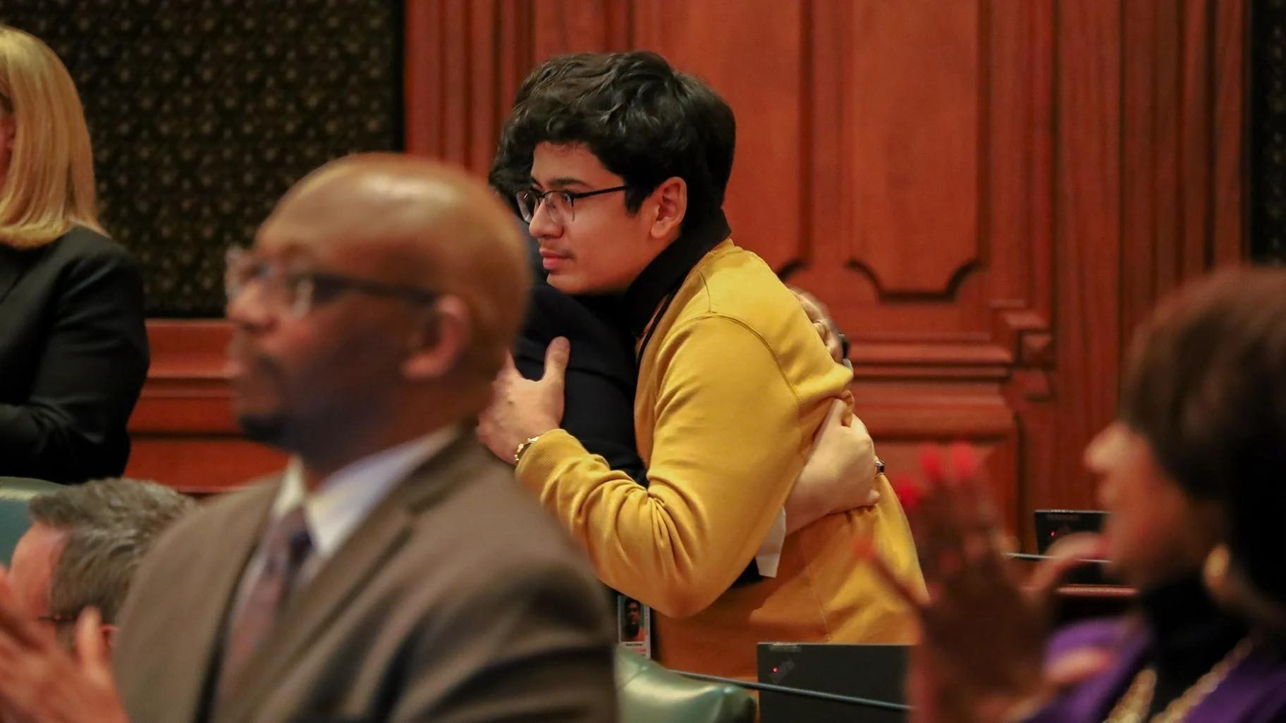 Manny Alvarez, son of Karina Gonzalez, hugs state Rep. Edgar Gonzalez Jr. (D-Chicago) in the Illinois House on Tuesday, Jan. 7, 2025. Karina Gonzalez, the namesake of the legislation, was allegedly shot and killed by her husband in Chicago in 2023 after receiving an order of protection. (Andrew Adams / Capitol News Illinois)