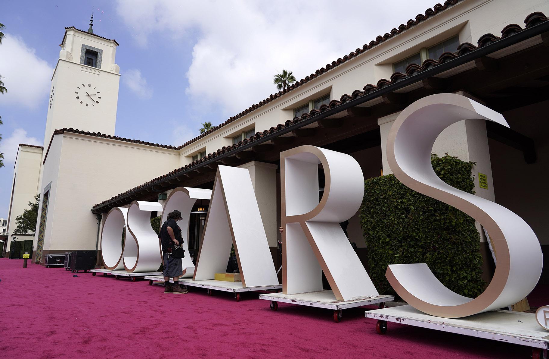 An Academy Awards crew member looks over a background element for the red carpet at Union Station, one of the locations for Sunday’s 93rd Academy Awards, Saturday, April 24, 2021, in Los Angeles. (AP Photo / Chris Pizzello)