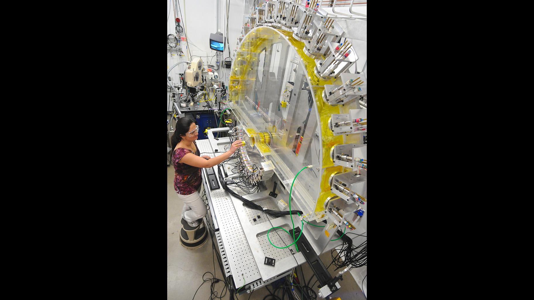 Argonne National Laboratory assistance materials scientist loads an in-situ-lithium-ion battery into the Low-Energy Resolution Inelastic X-ray (LERIX) system at the Advanced Photon Source. (U.S. Department of Energy / Flickr)