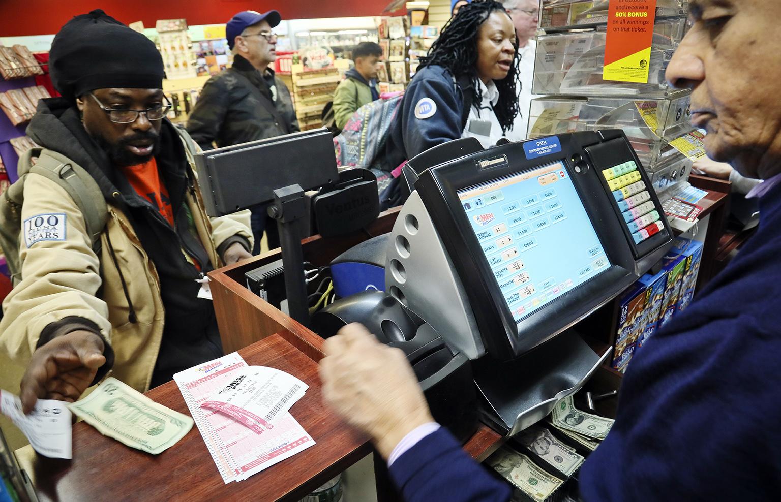 Lottery players buy Mega Millions lottery tickets on Friday, Oct. 19, 2018, in New York. The estimated jackpot for Friday's drawing has soared to  billion. (AP Photo / Bebeto Matthews)