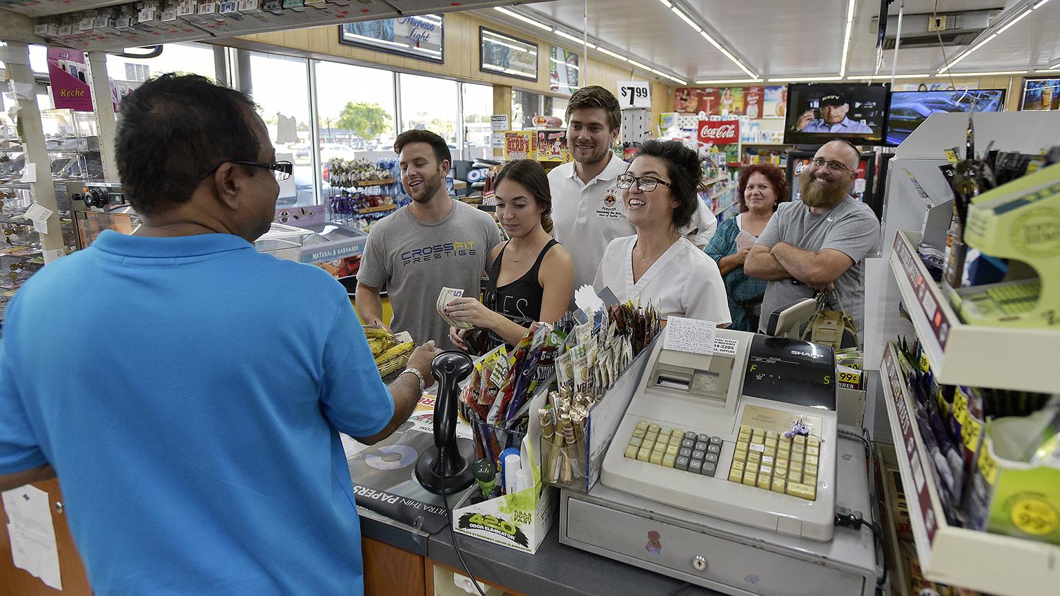 People line up at the Kwik Stop food store at 46th Avenue and Hollywood Boulevard, in Hollywood, Fla., to buy Mega Millions lottery tickets on Friday, Oct. 19, 2018.  (Michael Laughlin / South Florida Sun-Sentinel via AP)