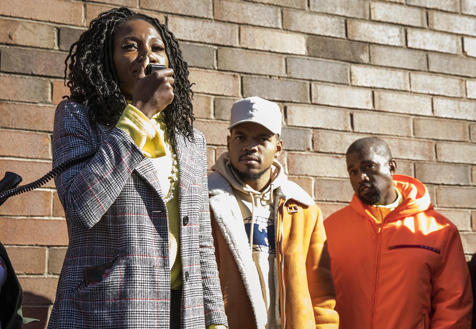 Chicago mayoral candidate Amara Enyia speaks as Chance the Rapper, center, and Kanye West listen during a "pull-up" rally for Enyia on Tuesday, Oct. 23, 2018, in Chicago. (Ashlee Rezin / Chicago Sun-Times via AP)