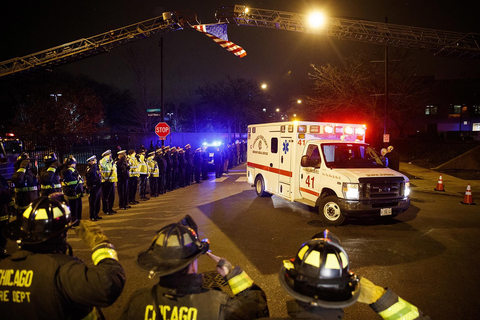 Police and firefighters salute as an ambulance arrives at the medical examiner's office carrying the body of Chicago Police Department Officer Samuel Jimenez, who was killed during a shooting at Mercy Hospital earlier in the day, Monday, Nov. 19, 2018. (Armando L. Sanchez / Chicago Tribune via AP)