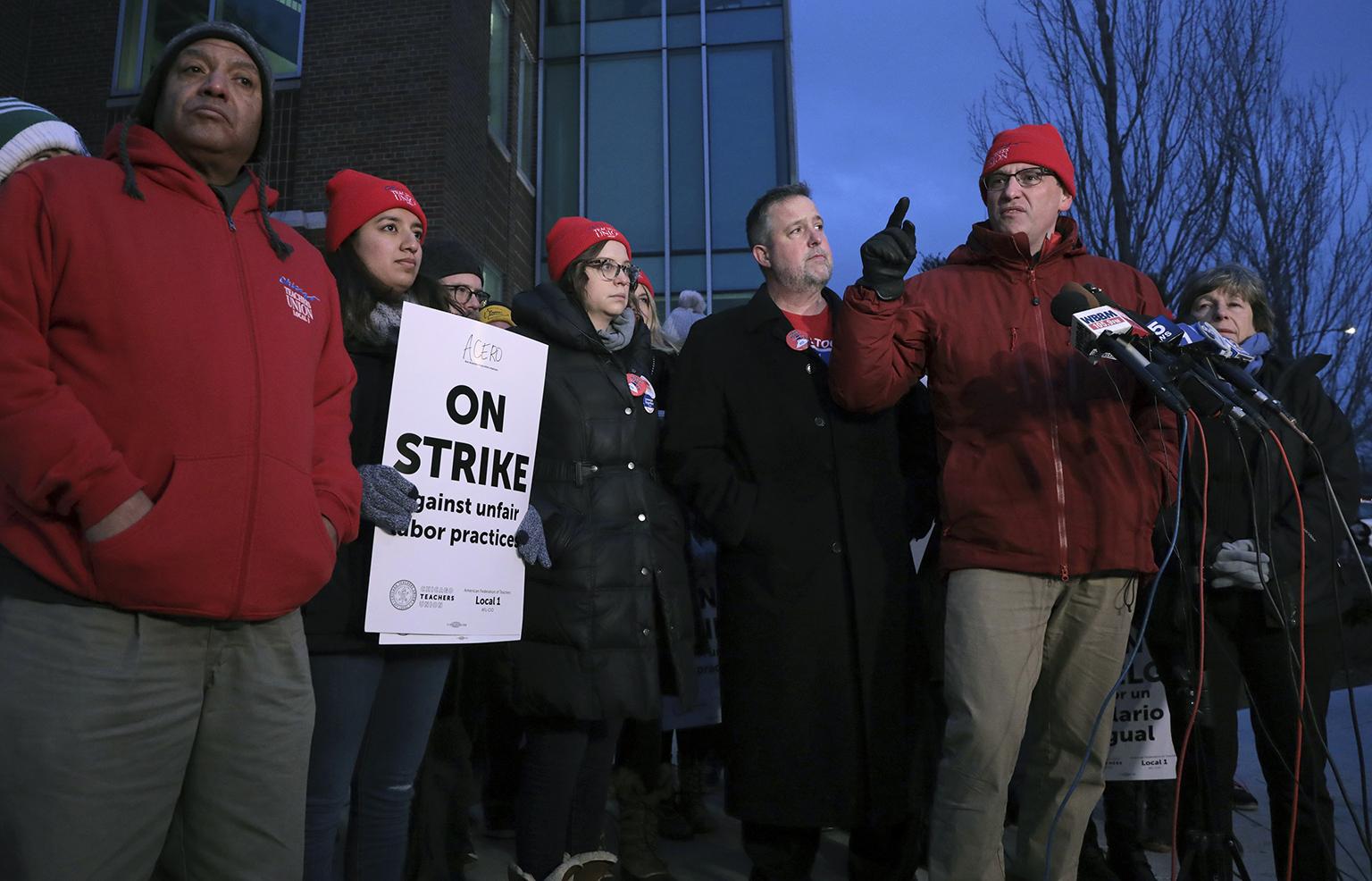 President of the Chicago Teachers Union Jesse Sharkey talks with members of the media as charter school teachers and their supporters walk the picket line outside the Acero’s Zizumbo Elementary Charter school on Tuesday, Dec. 4, 2018. (Antonio Perez / Chicago Tribune via AP)