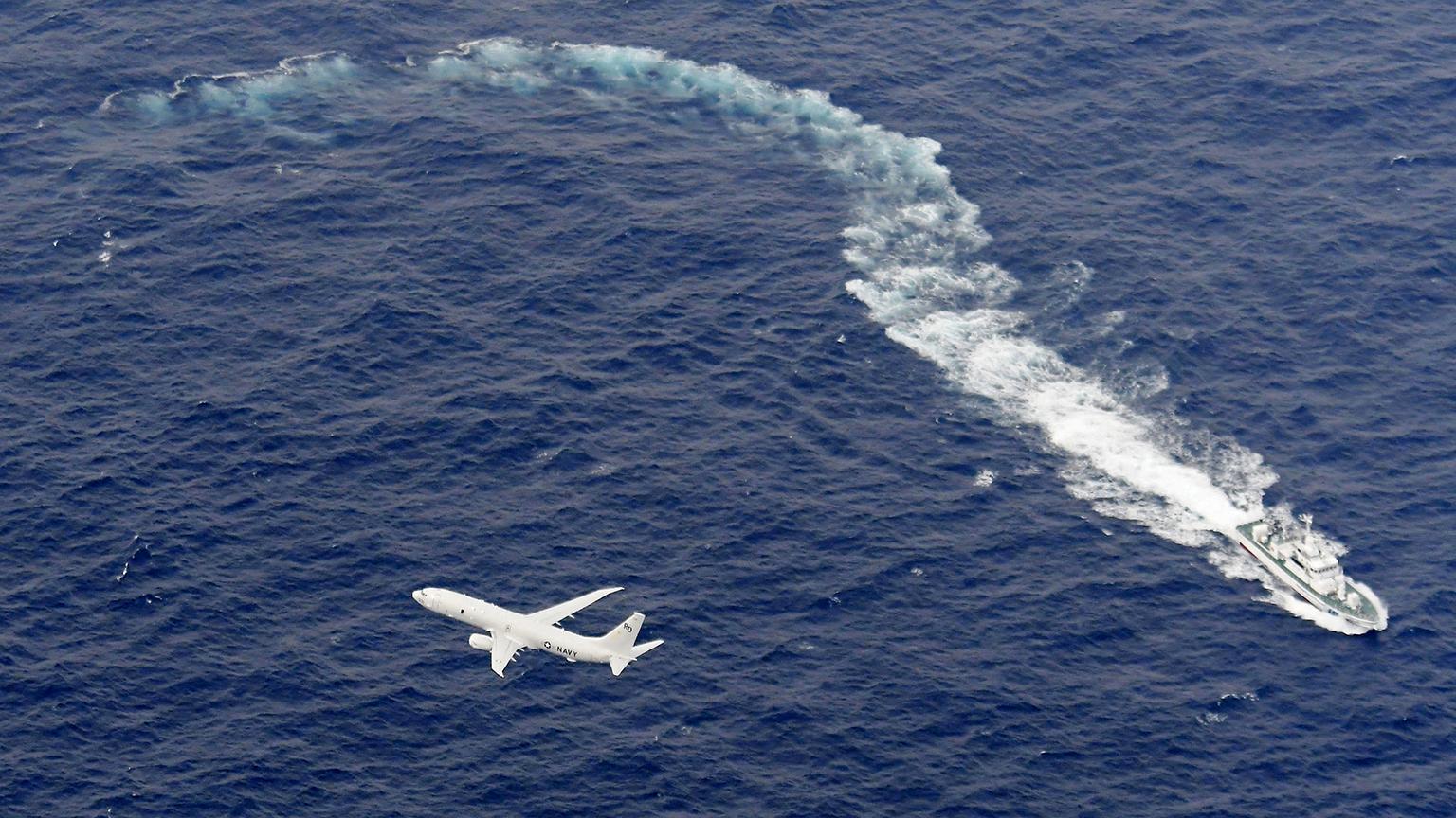 In this Dec. 6, 2018, file photo, Japan's Coast Guard ship, top, and U.S. military plane are seen at sea off Kochi, southwestern Japan, during a search and rescue operation for missing crew members of a U.S. Marine refueling plane and fighter jet. (Kyodo News via AP, File)