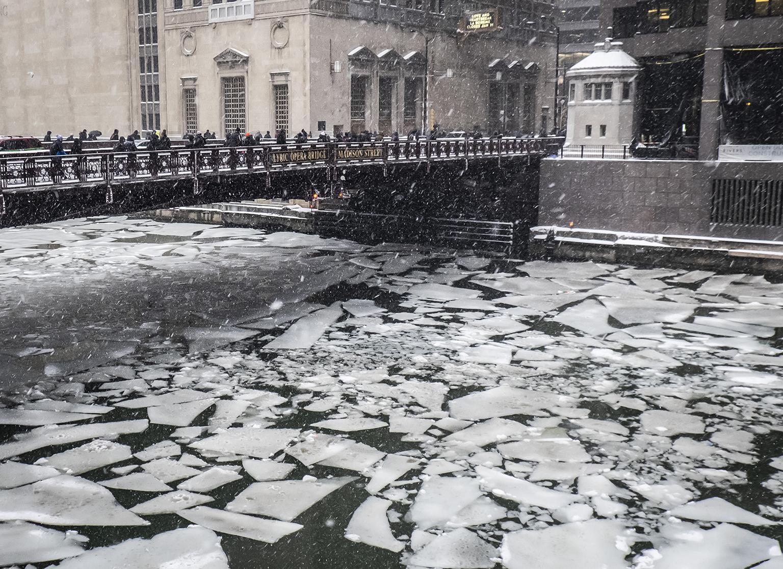 Pedestrians cross an icy Chicago River on Madison Street near the Civic Opera House on Monday, Jan. 28, 2019. (Rich Hein / Chicago Sun-Times via AP)