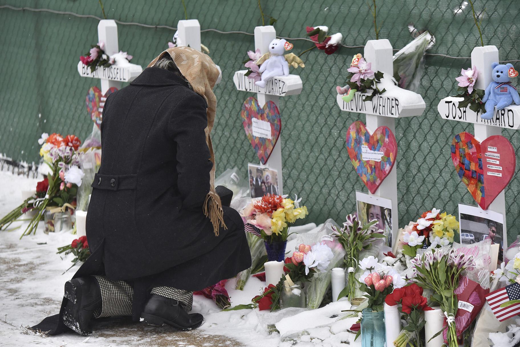 Mourners place flowers at the crosses outside of the Henry Pratt Co. in Aurora, Illinois, on Sunday, Feb. 17, 2019, in memory of the five employees killed on Friday. (Jeff Knox / Daily Herald via AP)