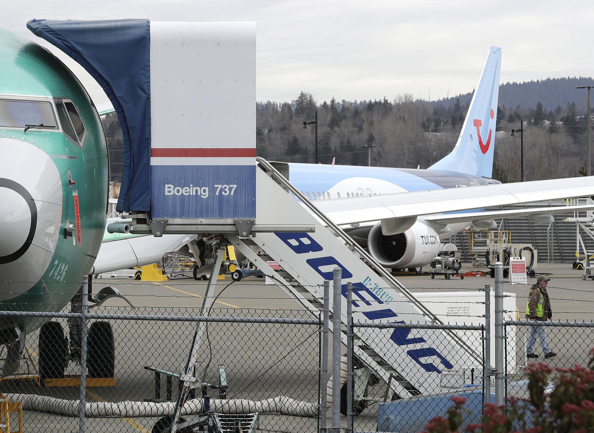 In this photo taken Monday, March 11, 2019, a Boeing 737 MAX 8 airplane being built for TUI Group sits parked in the background at right at Boeing Co.'s Renton Assembly Plant in Renton, Washington.  (AP Photo / Ted S. Warren)