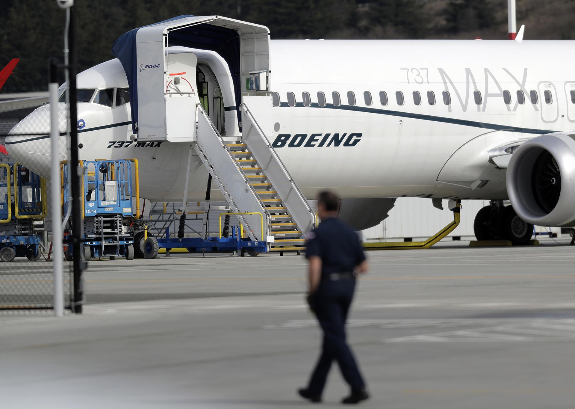 In this March 14, 2019, file photo a worker walks next to a Boeing 737 MAX 8 airplane parked at Boeing Field in Seattle. (AP Photo / Ted S. Warren, File)