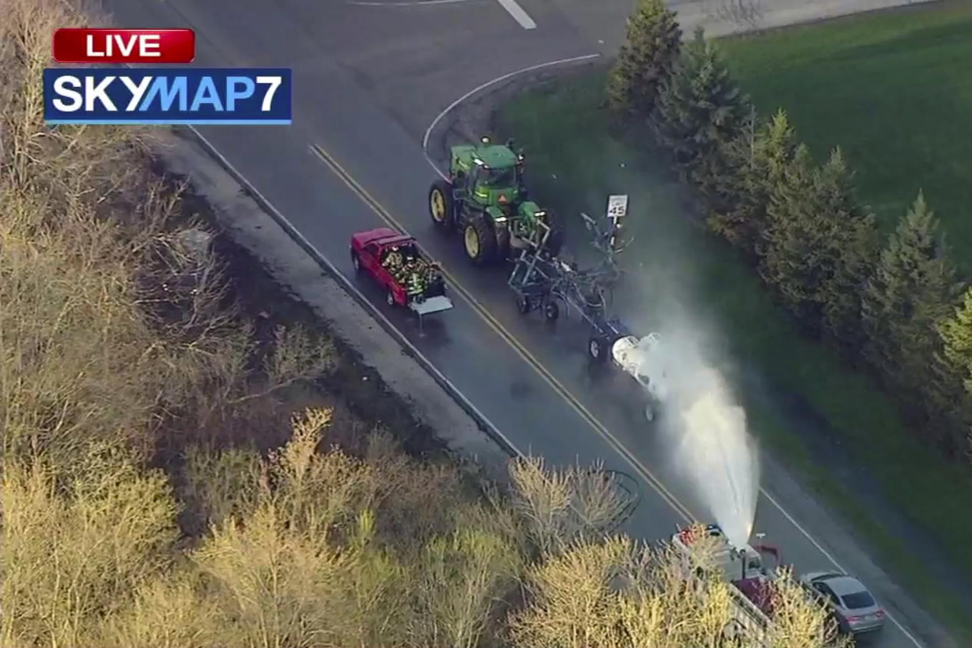 In this still image from video provided by ABC7 Chicago, a fire engine sprays water on a container of the chemical that farmers use for soil after anhydrous ammonia leaked Thursday, April 25, 2019, in Beach Park, Illinois. (ABC7 Chicago via AP)