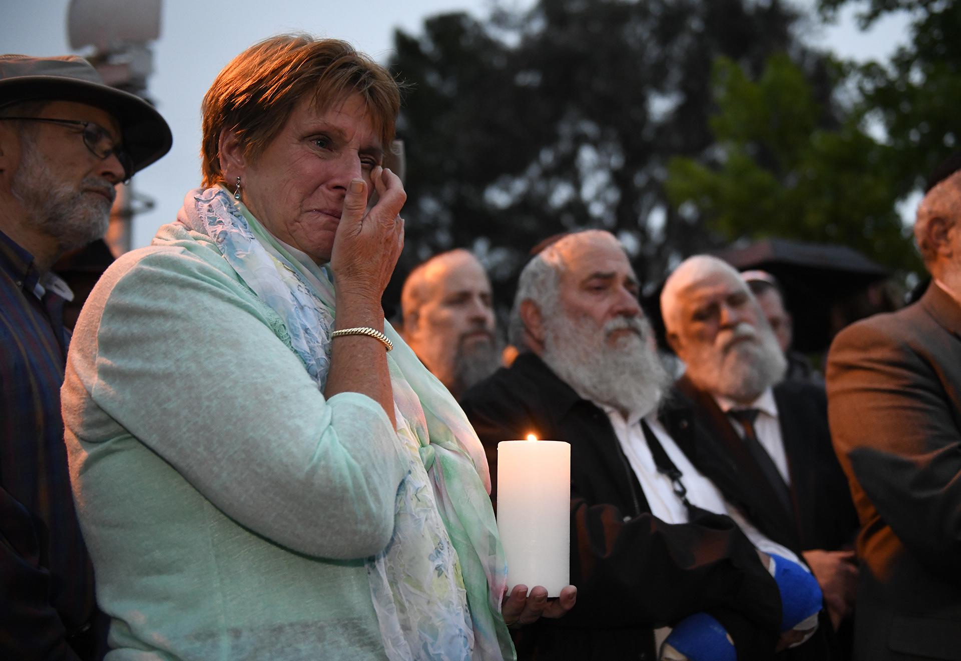 A woman cries during a candlelight vigil held for victims of the Chabad of Poway synagogue shooting, Sunday, April 28, 2019, in Poway, California. (AP Photo / Denis Poroy)