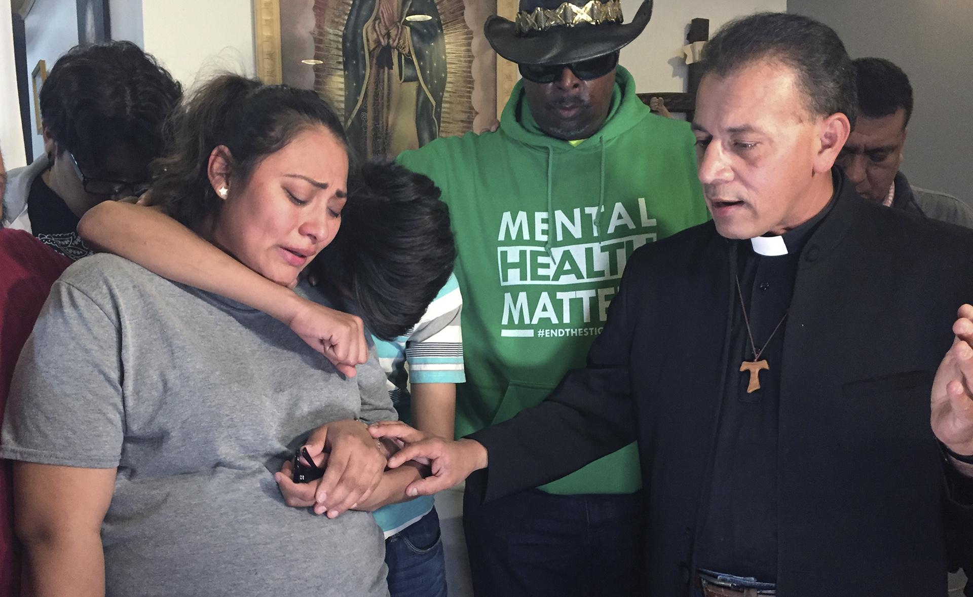In this Tuesday, May 21, 2019 photo provided by WBEZ Radio is Adilene Marquina, left, as she sobs after announcing she will be seeking sanctuary inside Faith, Life and Hope Mission church on Chicago's Southwest Side. Hugging her is her son, Johan as Rev. Jose Landaverde, right, comforts her. (María Ines Zamudio / WBEZ Radio via AP)