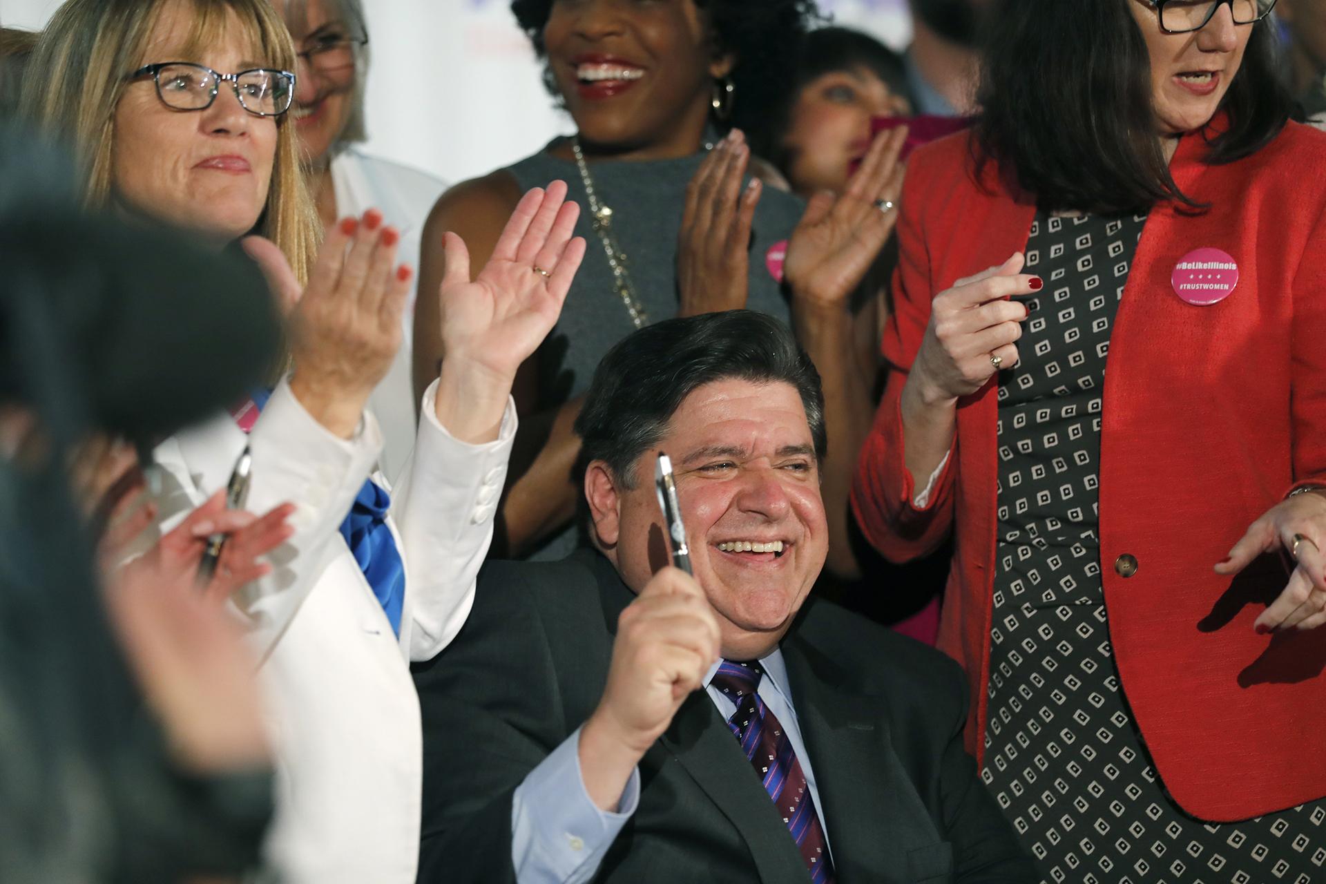Illinois Gov. J.B. Pritzker signs the Reproductive Health Act into law with bill sponsors Illinois State Senator Melinda Bush, left, and Illinois State Rep. Kelly Cassidy, right, at the Chicago Cultural Center on Wednesday, June 12, 2019. (Jose M. Osorio / Chicago Tribune via AP)