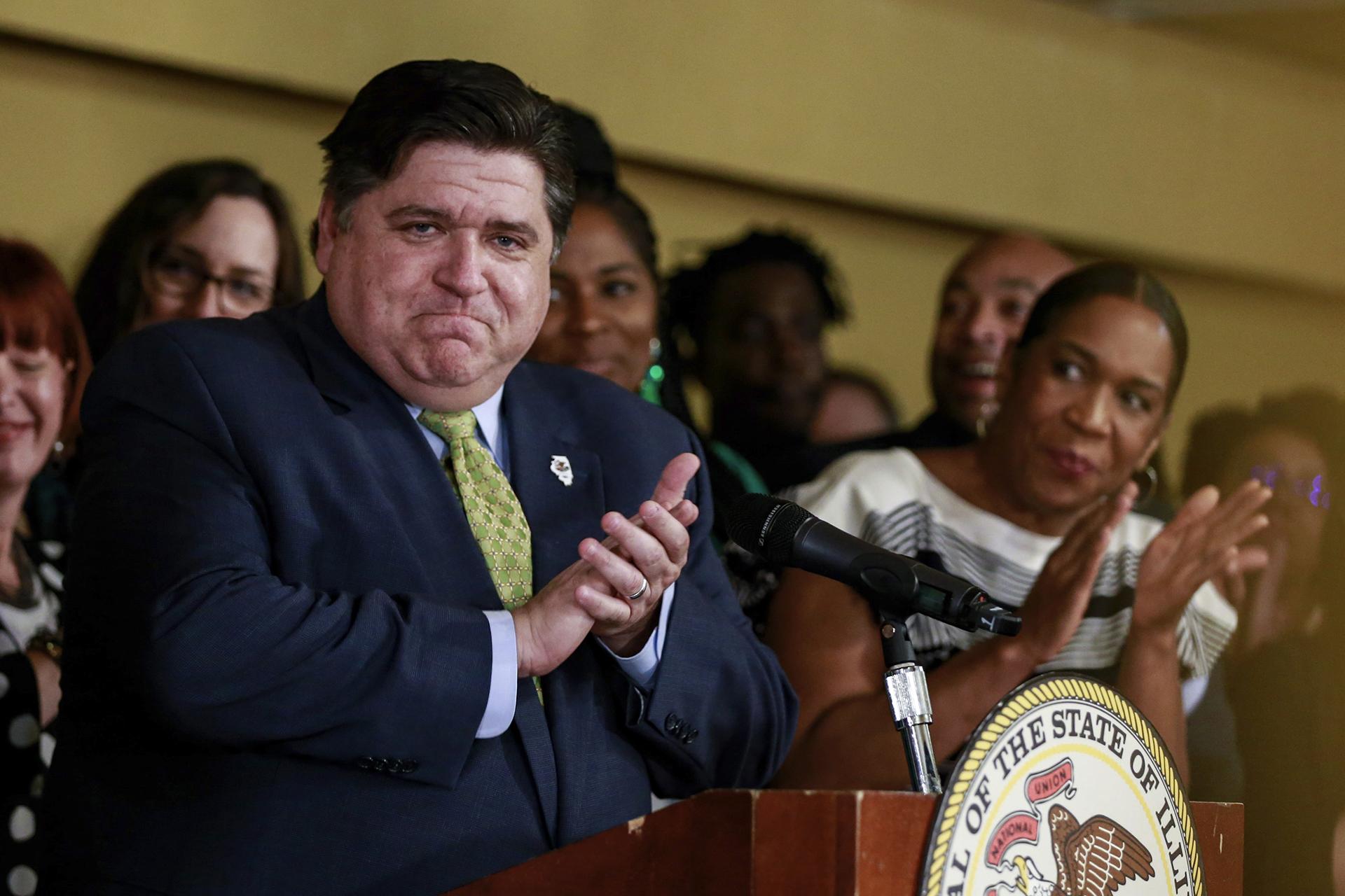 Gov. J.B. Pritzker takes in the applause before signing a bill that legalizes adult-use cannabis in the state of Illinois at Sankofa Cultural Arts and Business Center in Chicago. (AP Photo / Amr Alfiky)
