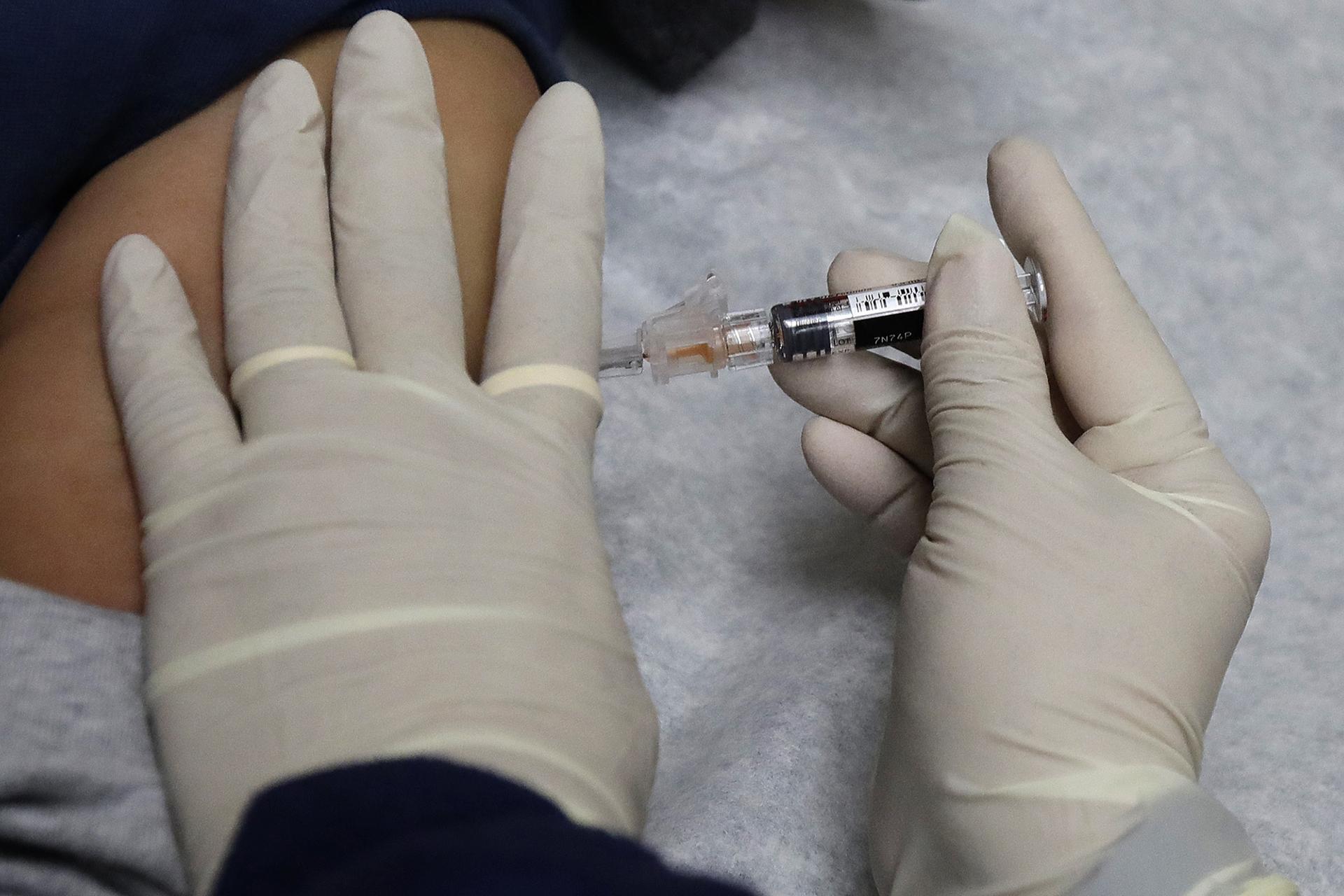 In this Jan. 12, 2018, file photo, a medical assistant at a community health center gives a patient a flu shot in Seattle. (AP Photo / Ted S. Warren, File)