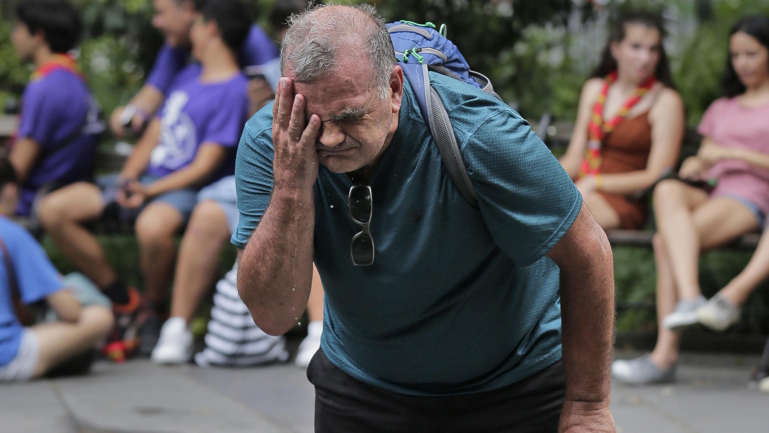 Russ Wilson splashes water on his face from a fountain in New York, Wednesday, July 17, 2019. The heat wave that has been roasting much of the U.S. in recent days is just getting warmed up, with temperatures expected to soar to dangerous levels through the weekend. (AP Photo / Seth Wenig)