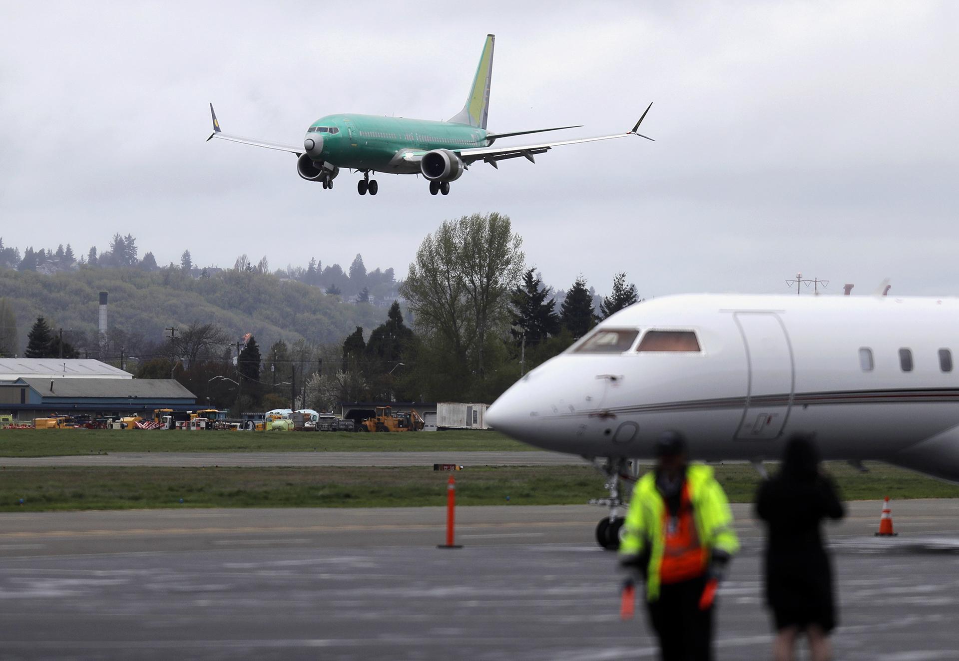 In this April 10, 2019, file photo a Boeing 737 MAX 8 airplane being built for India-based Jet Airways, top, lands following a test flight, Wednesday, April 10, 2019, at Boeing Field in Seattle. (AP Photo / Ted S. Warren, File)