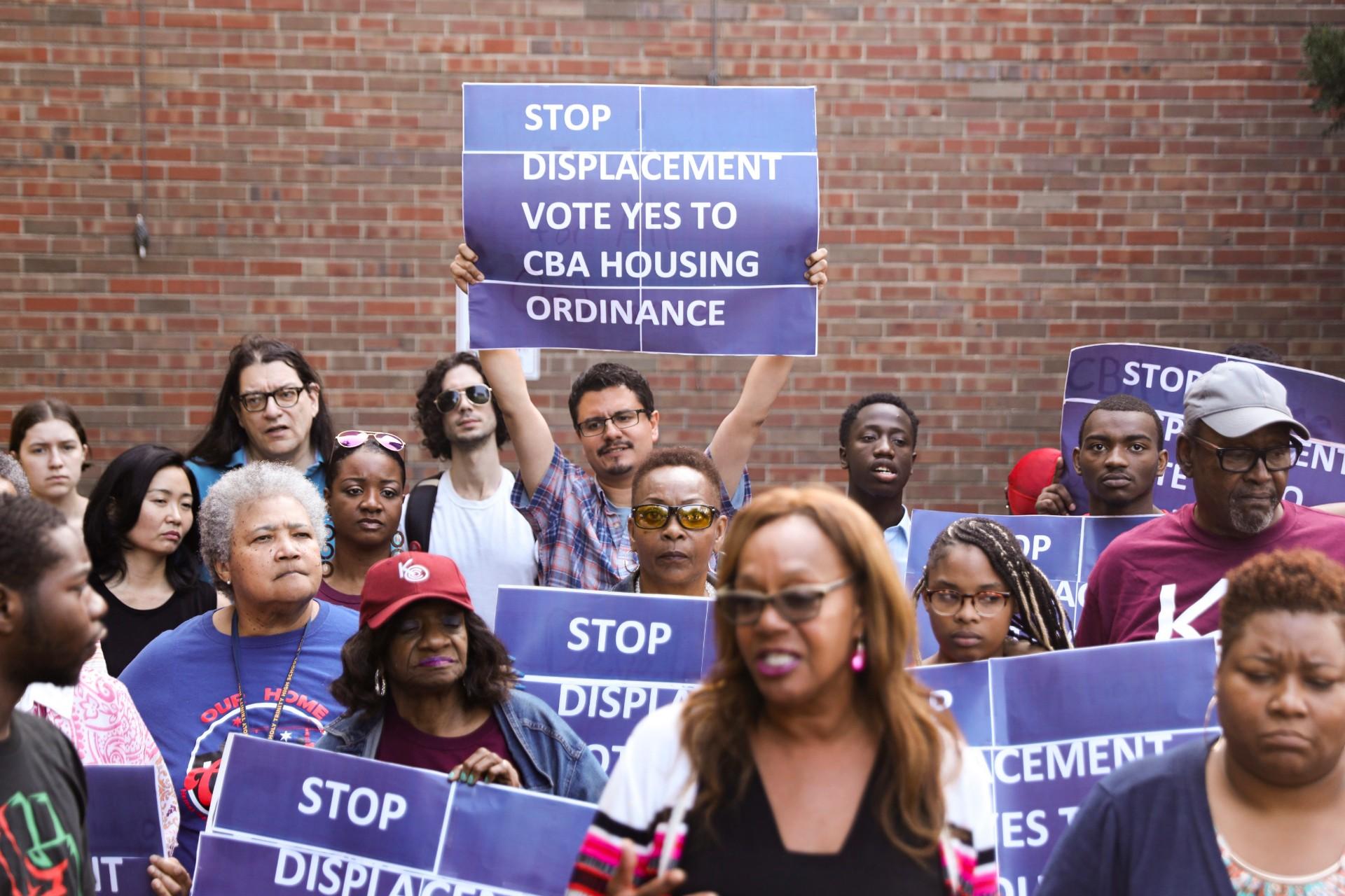 In this Tuesday, July 23, 2019 photo, activist Jose Reuena, center in back row, holds a placard during a news conference and rally in Chicago. (AP Photo / Amr Alfiky)