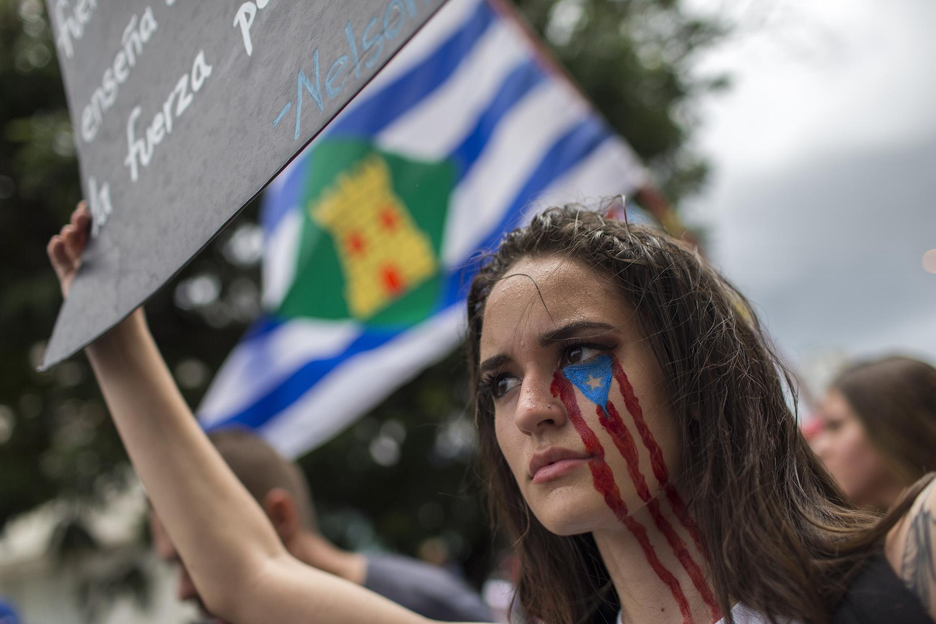 In this July 25, 2019 photo, a young woman takes part in the festivities to celebrate the resignation of Gov. Ricardo Rossello, after weeks of protests over leaked obscene, misogynistic online chats, in San Juan, Puerto Rico. (AP Photo / Dennis M. Rivera Pichardo)