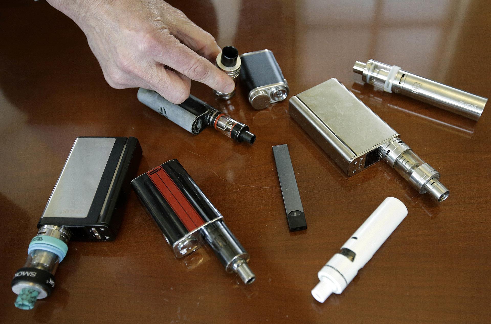 In this Tuesday, April 10, 2018 photo, a high school principal displays vaping devices that were confiscated from students at the school in Massachusetts. (AP Photo / Steven Senne)