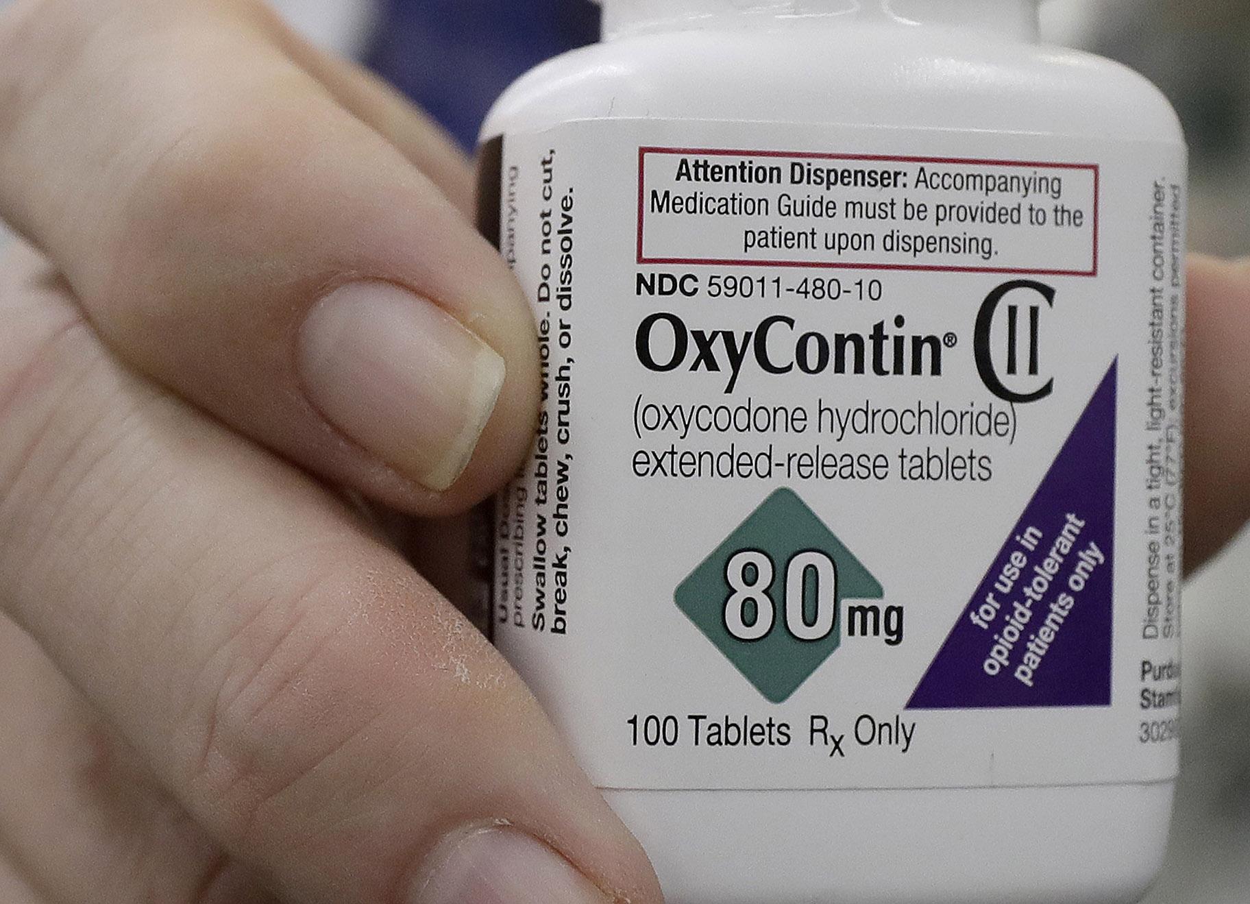 In this April 2, 2018, file photo, a pharmacist in San Francisco poses for photos holding a bottle of OxyContin. (AP Photo / Jeff Chiu, File)