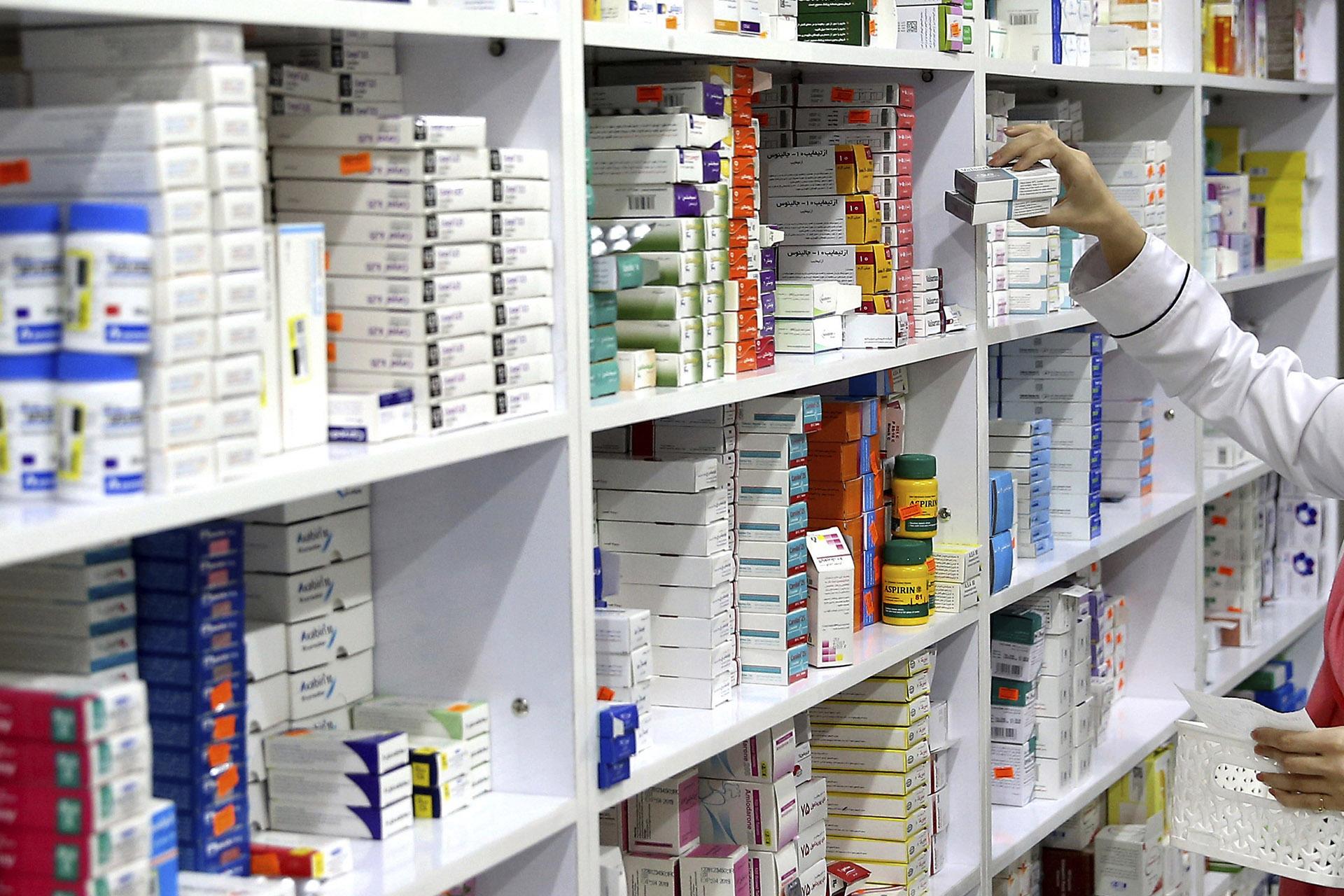 In this Nov. 5, 2018 file photo, a drugstore employee reaches for medicine from shelf in downtown Tehran, Iran. (AP Photo / Ebrahim Noroozi, File)