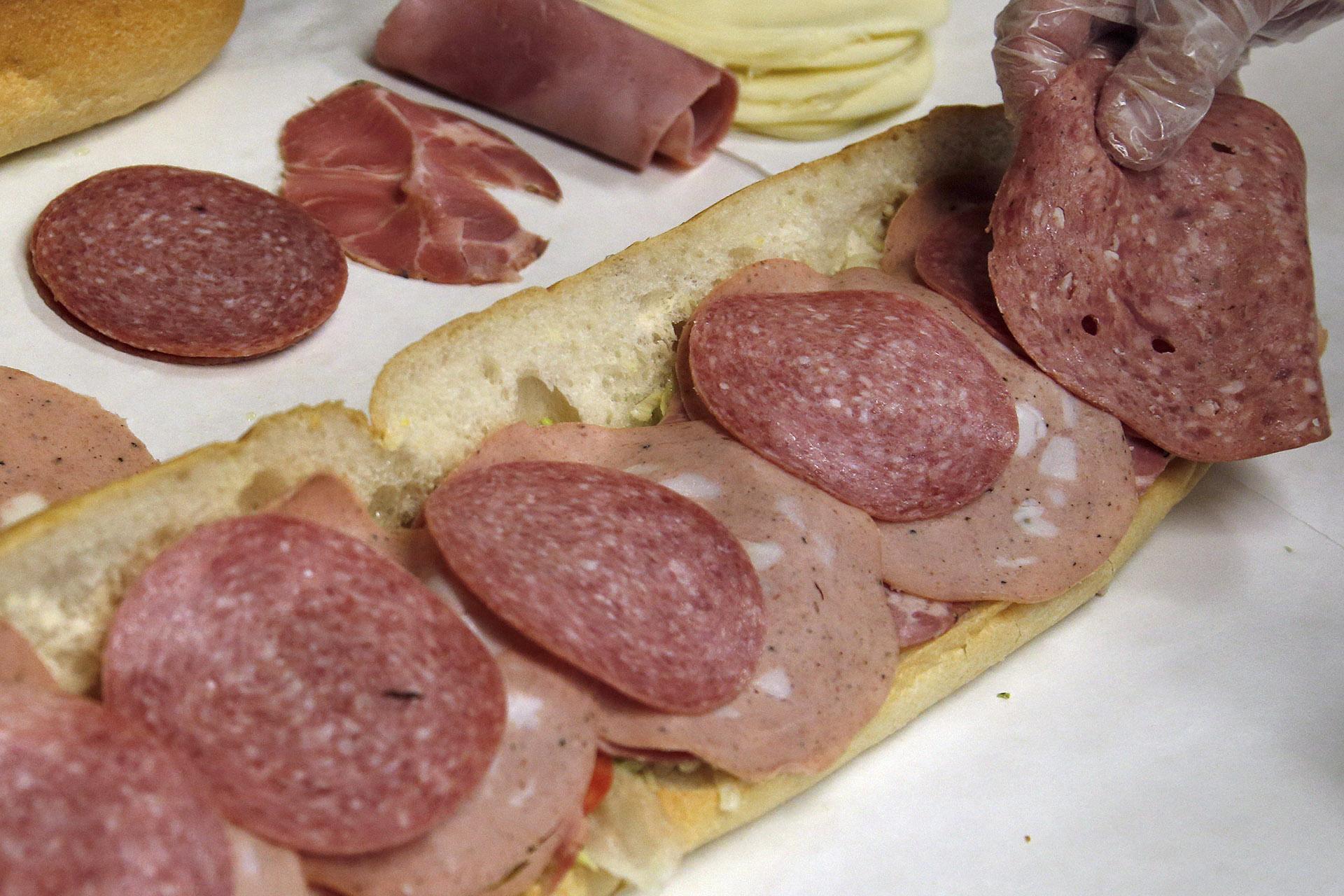  In this June 5, 2014, file photo, a man makes a submarine sandwich with mortadella, cooked salami, ham, Genoa salami and sweet capicola at a delicatessen in Massachusetts. (AP Photo / Elise Amendola, File)