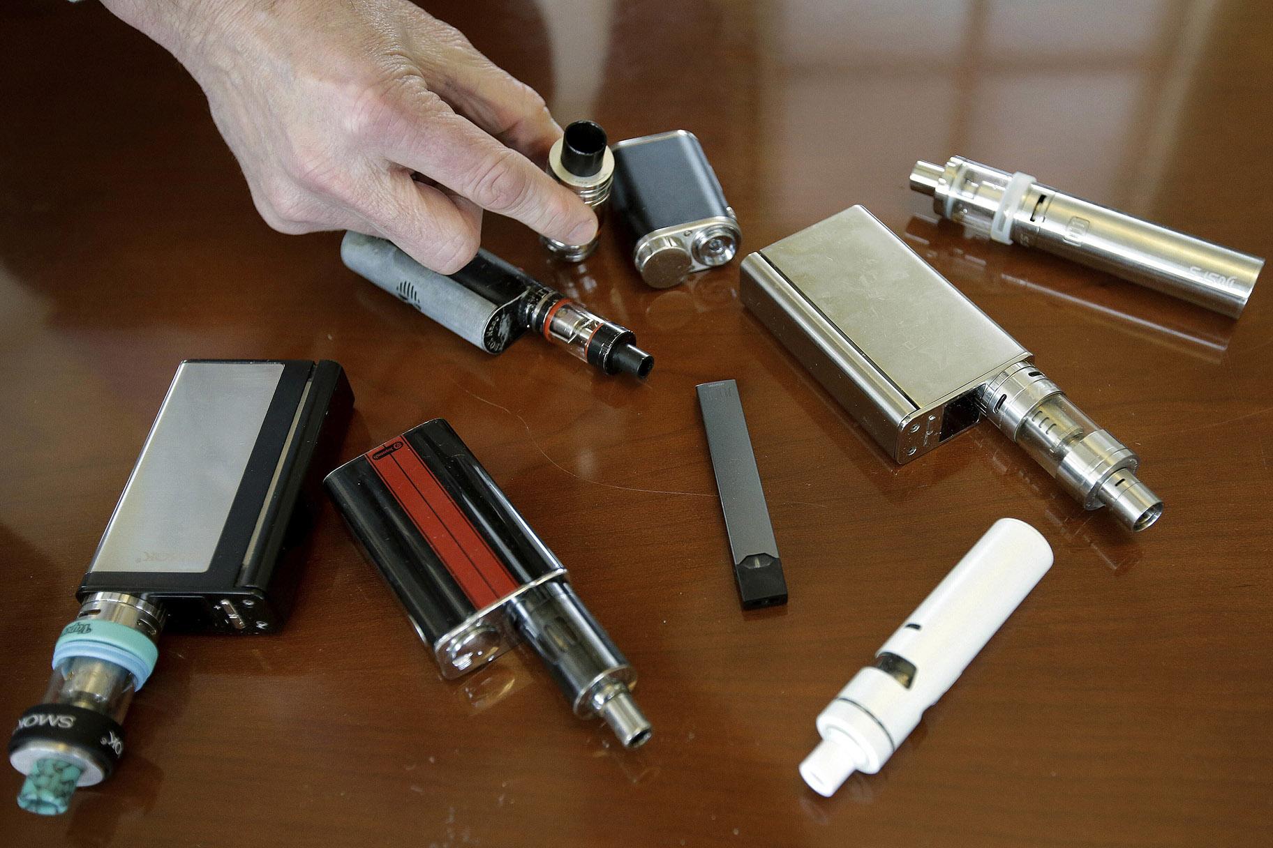 In this Tuesday, April 10, 2018 photo, a high school principal displays vaping devices that were confiscated from students at the school in Massachusetts. (AP Photo / Steven Senne)