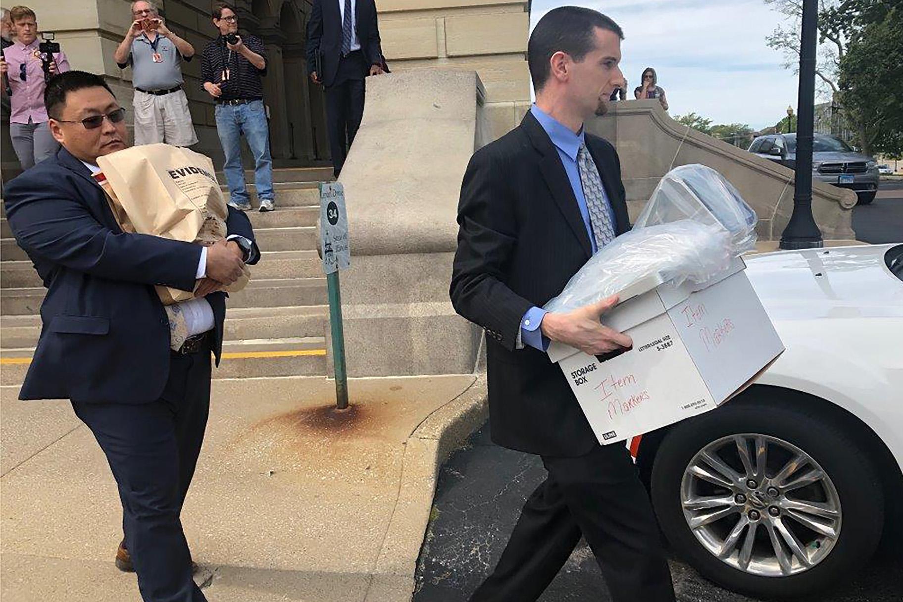 Men carrying boxes and a bag marked “evidence” leave the Illinois State Capitol on Tuesday, Sept. 24, 2019 after a raid at the office of state Sen. Martin Sandoval. (AP Photo/John O’Connor, File)