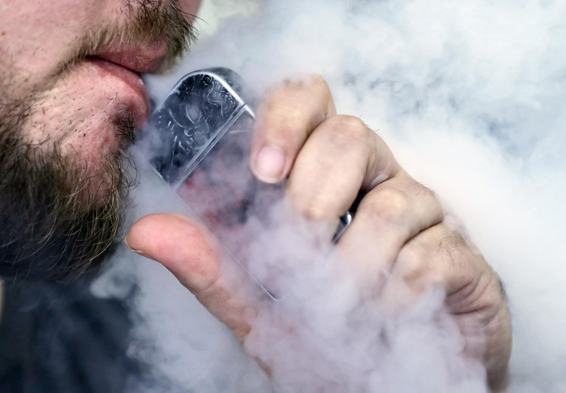 In this Friday, Oct. 4, 2019, file photo, a man using an electronic cigarette exhales in Mayfield Heights, Ohio. (AP Photo / Tony Dejak, File)
