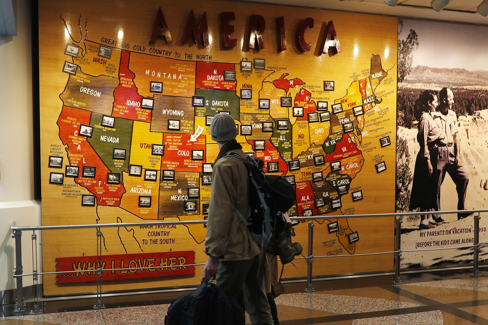 In this Nov. 21, 2018, file photo, travelers pass by a map of the United States on the way to a security checkpoint at Denver International Airport in Denver. (AP Photo / David Zalubowski, File)