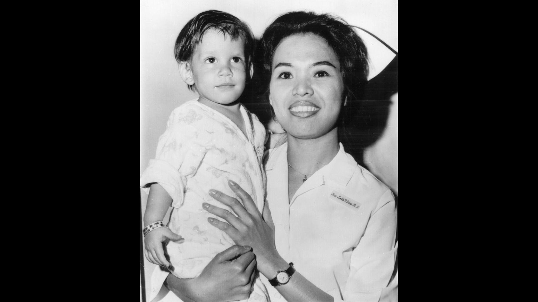 In this June 17, 1966 file photo, a boy, dubbed “Scott McKinley” by the State Child Service is held by Nurse Lolita V. Tana in Newark, N.J. McKinley has been adopted by Chester and Dora Fronczak, a Chicago couple who believe him to be their son kidnapped in 1964. (AP Photo, File)