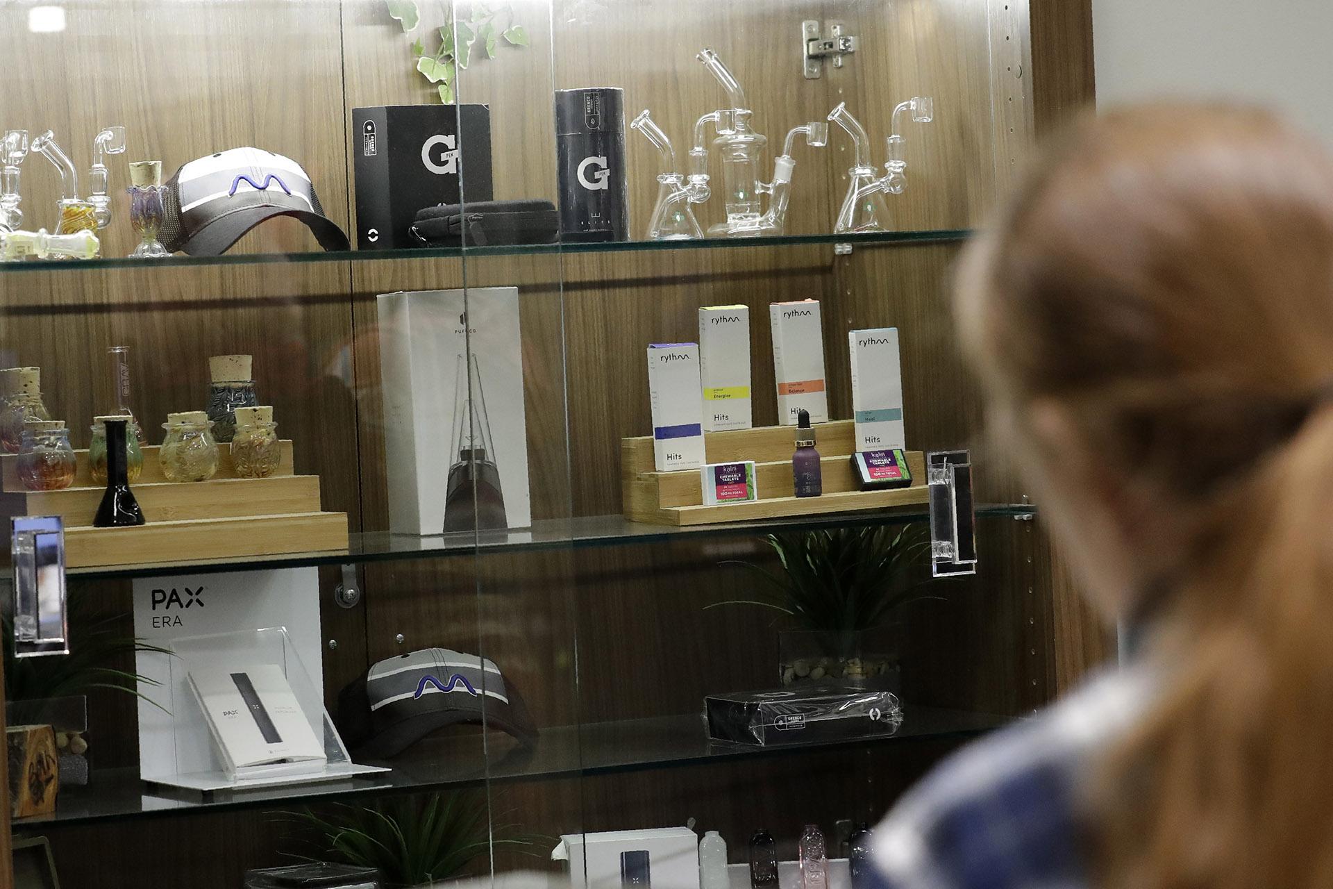 In this Thursday, Dec. 26, 2019 photo, a registered medical marijuana patient looks at products at the Rise cannabis store in Mundelein, Illinois. Starting Jan. 1, 2020, Illinois will join Michigan as the only Midwestern states broadly allowing the sale and use of marijuana. (AP Photo / Nam Y. Huh)