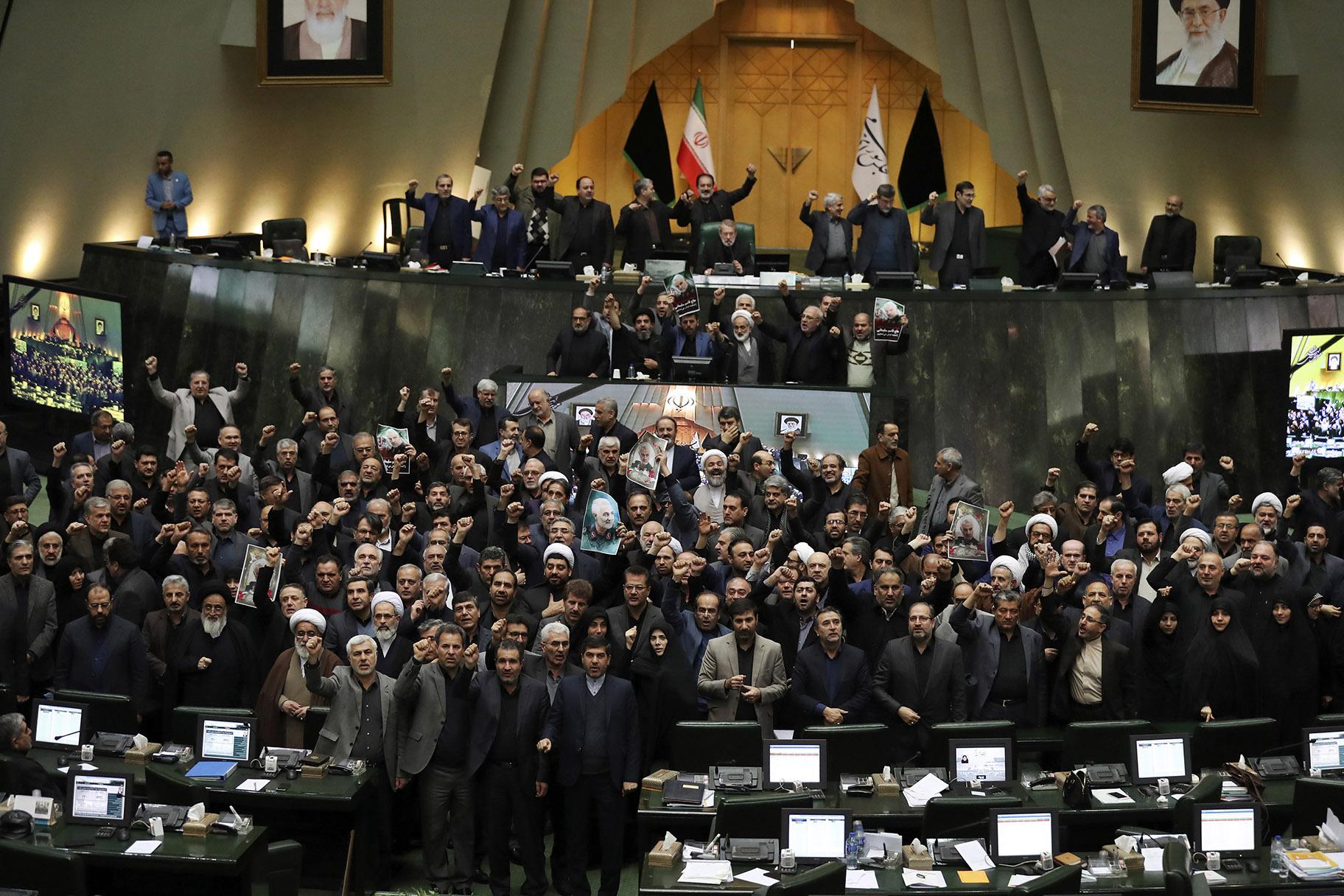 Iranian lawmakers chant slogans as some of them hold posters of Gen. Qassem Soleimani, who was killed in Iraq in a U.S. drone attack, in an open session of parliament, in Tehran, Iran, Tuesday, Jan. 7, 2020. (AP Photo / Vahid Salemi)