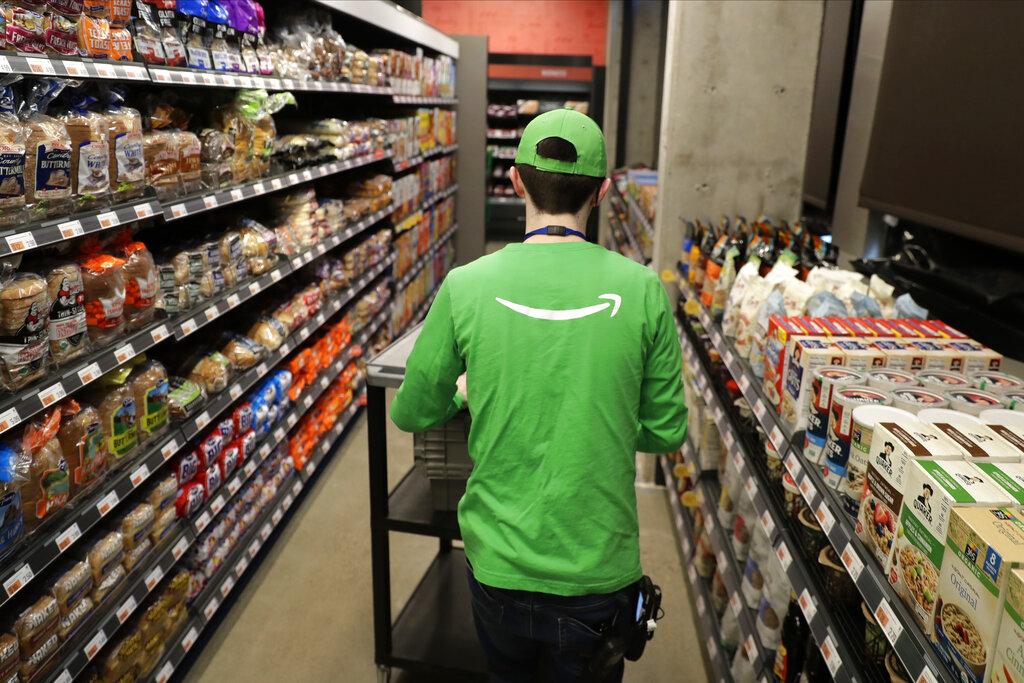 In this Feb. 21, 2020 photo, a worker pushes a cart inside an Amazon Go Grocery store set to open soon in Seattle’s Capitol Hill neighborhood. (AP Photo / Ted S. Warren)