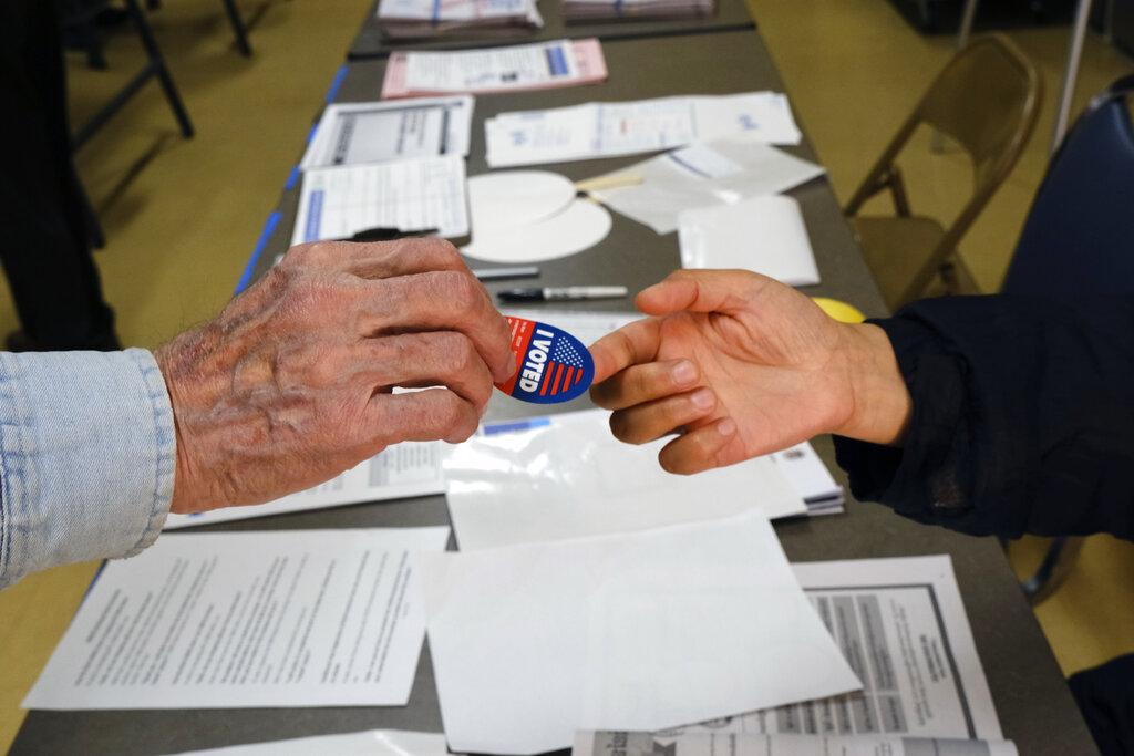 Early voter receives his I-Voted sticker, at an early voting polling station at the Ranchito Avenue Elementary School in the Panorama City section of Los Angeles on Monday, March 2, 2020. (AP Photo / Richard Vogel)