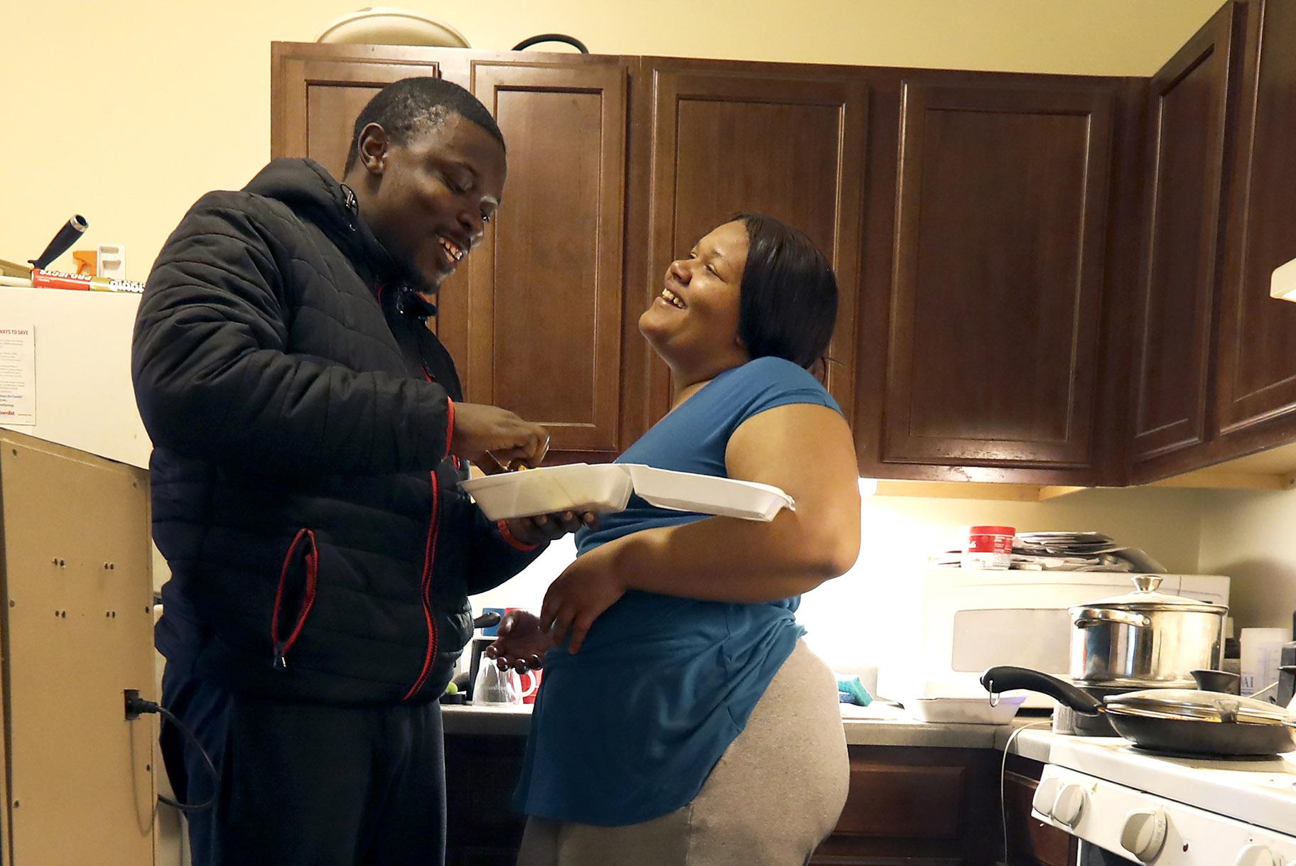In this Thursday, Feb. 27, 2020, photo, Richard Butler and his fiance Amber laugh while they have breakfast in an apartment a friend is letting them live in on Chicago’s South Side. (AP Photo / Charles Rex Arbogast)