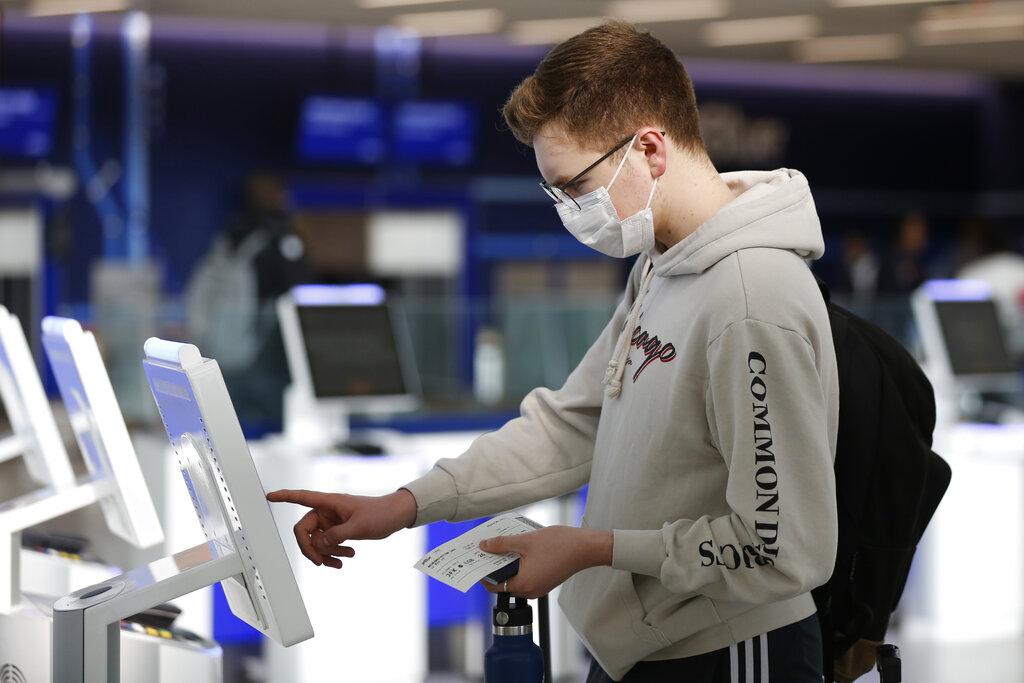 New York University student Hector Medrano, of Los Angeles, checks in for his flight using a touchscreen Saturday, March 14, 2020, at jetBlue's terminal in John F. Kennedy International Airport in New York. (AP Photo / Kathy Willens)