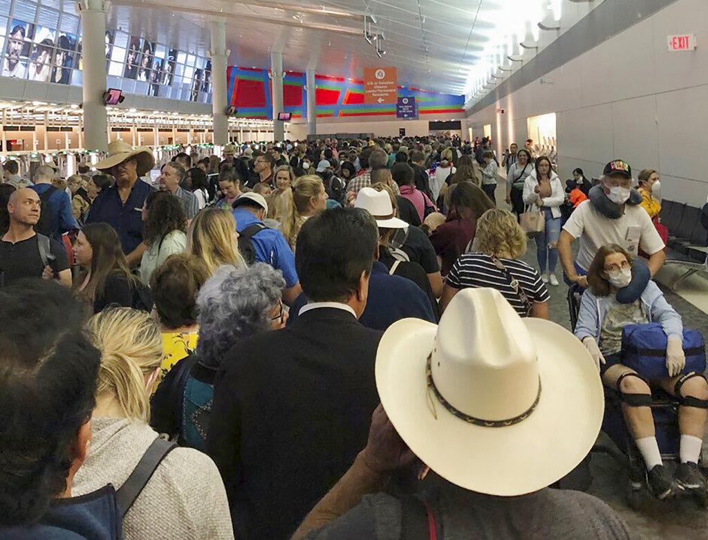 In this photo provided by Austin Boschen, people wait in line to go through the customs at Dallas Fort Worth International Airport in Grapevine, Texas, Saturday, March 14, 2020. (Austin Boschen via AP)