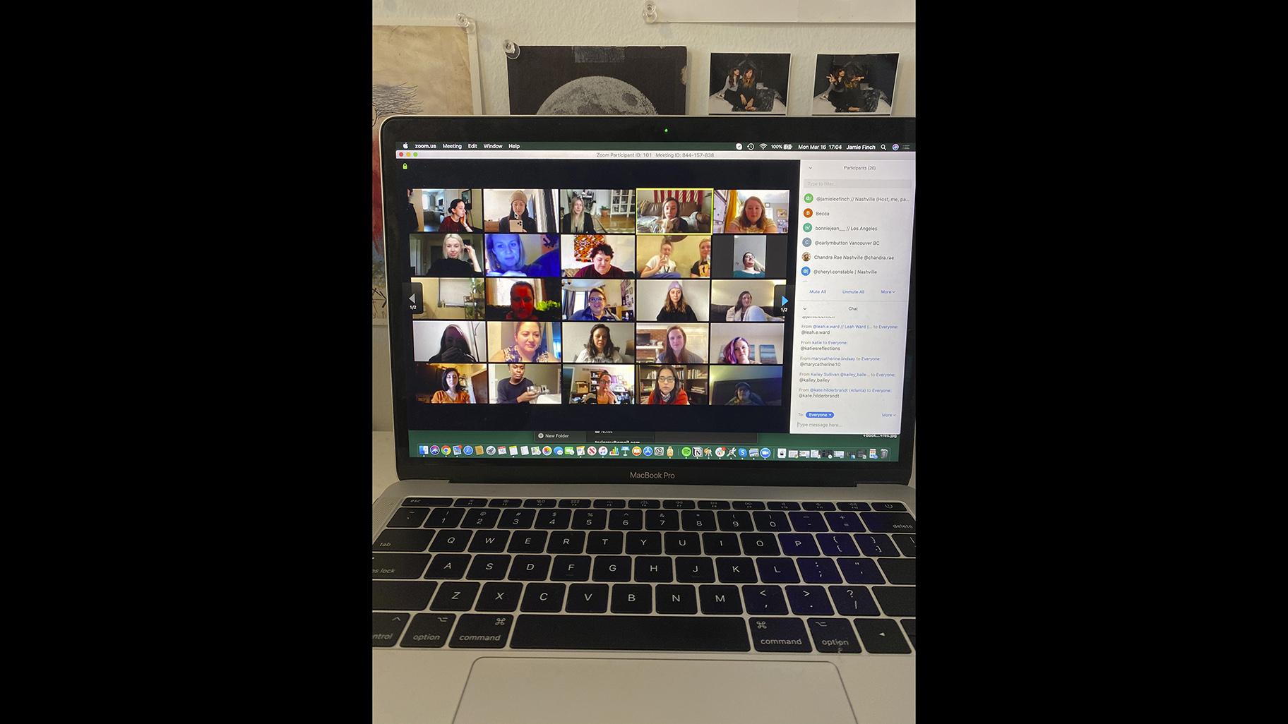 In this March 16, 2020 photo provided by Jamie Lee Finch, a laptop on a desk in Nashville, Tenn., shows people gathered together online for a virtual happy hour. (Jamie Lee Finch via AP)