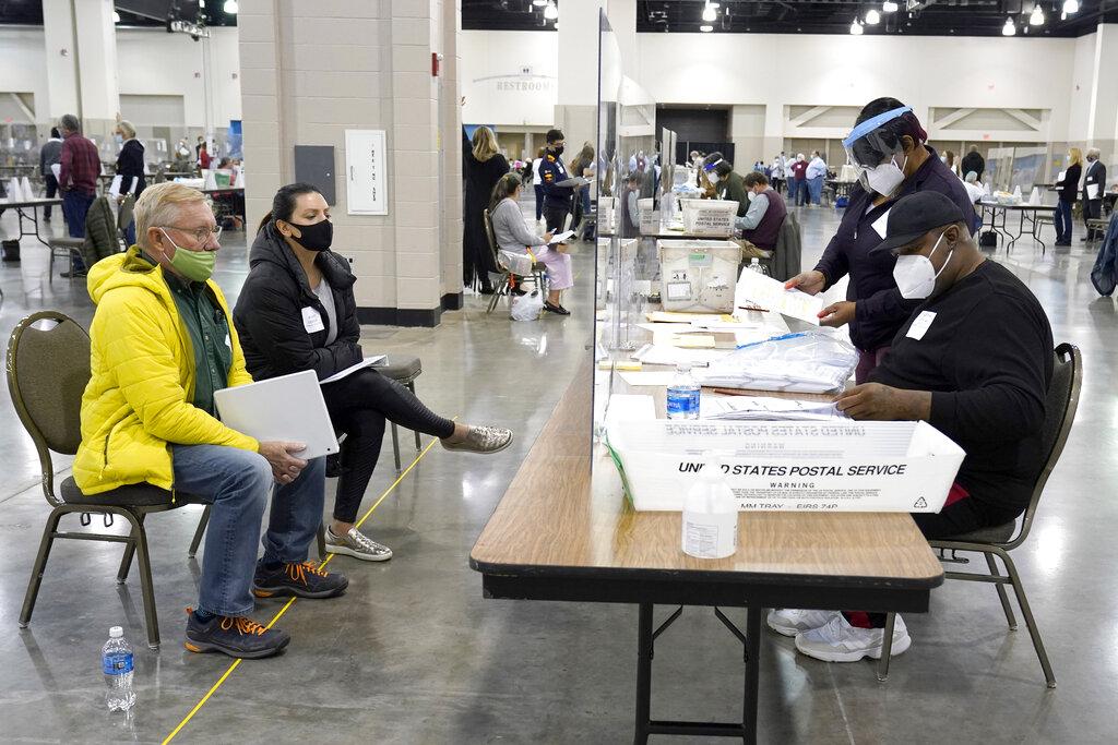 Election workers, right, verify ballots as recount observers, left, watch during a Milwaukee hand recount of presidential votes at the Wisconsin Center, Friday, Nov. 20, 2020, in Milwaukee. (AP Photo / Nam Y. Huh)