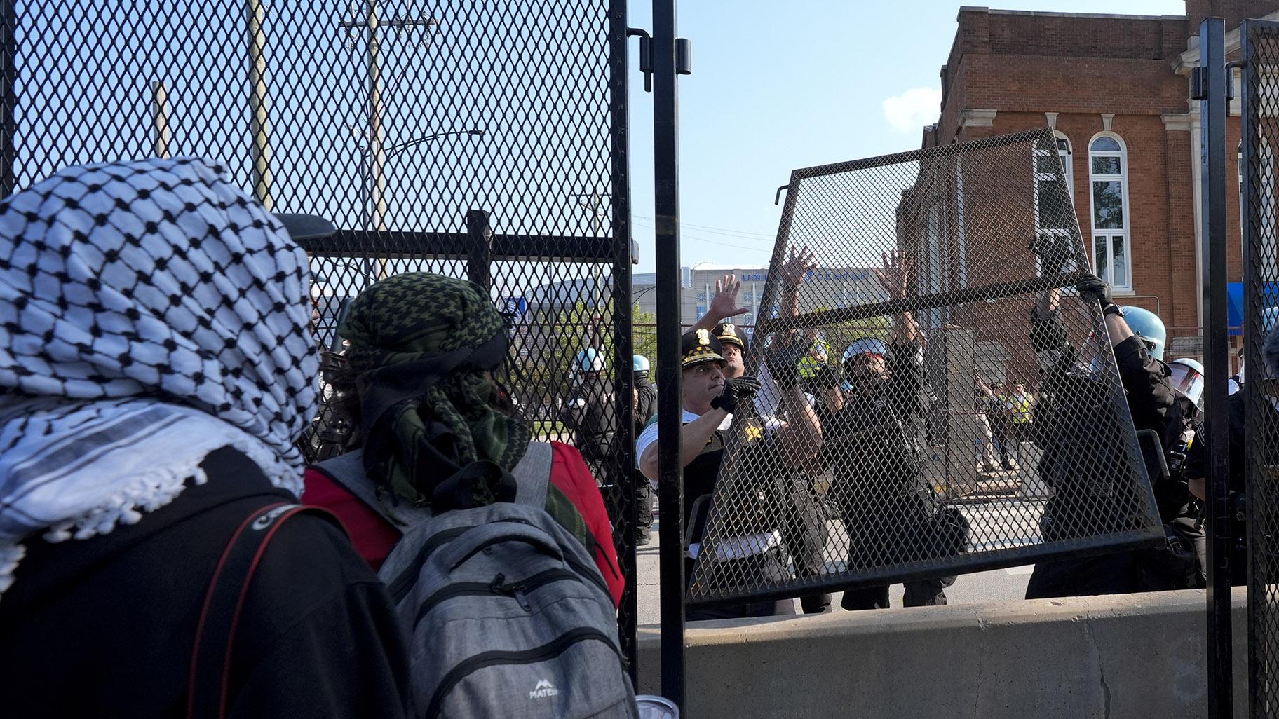 Police replace a piece of fence knocked down by protesters surrounding the United Center at the Democratic National Convention after a march Monday, Aug. 19, 2024, in Chicago. (AP Photo / Frank Franklin II)