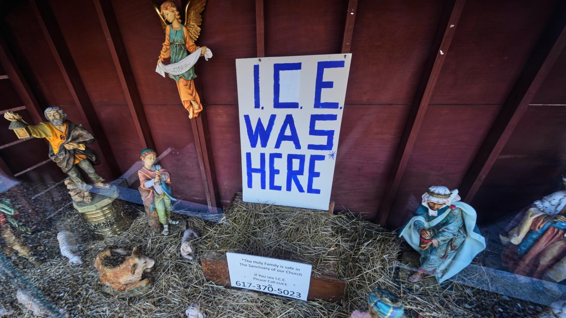 An "ICE WAS HERE" sign is posted in the empty spot for the baby Jesus at a Nativity scene displayed at St. Susanna Church, Tuesday, Dec. 9, 2025, in Dedham, Mass. (AP Photo / Charles Krupa)