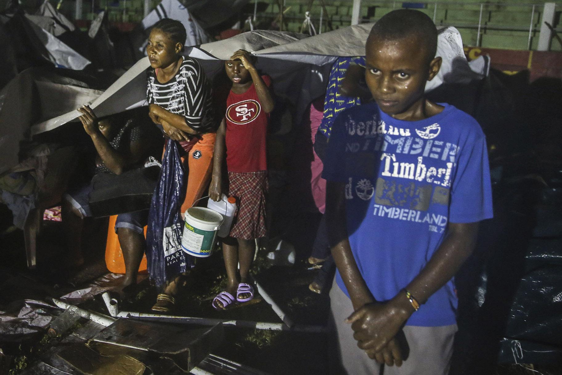 People affected by the Saturday’s earthquake take cover from the rain of Tropical Depression Grace at a refugee camp in Les Cayes, Haiti, Monday, Aug. 16, 2021. (AP Photo / Joseph Odelyn)