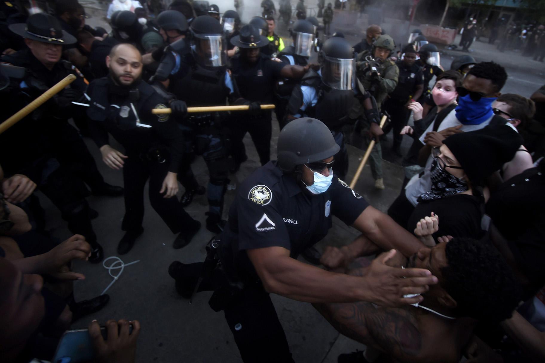 Police officers and protesters clash near CNN Center, Friday, May 29, 2020, in Atlanta, in response to George Floyd’s death in police custody in Minneapolis on Memorial Day. The protest started peacefully earlier in the day before demonstrators clashed with police. (AP Photo / Mike Stewart)