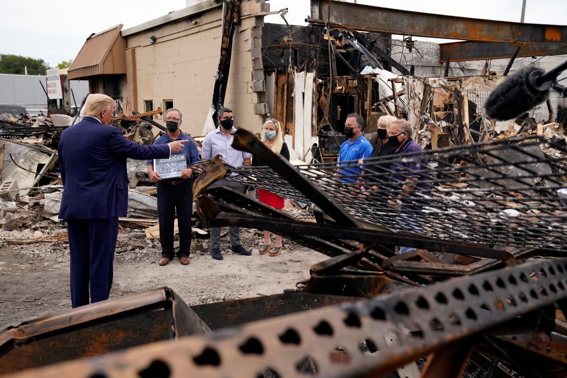 President Donald Trump talks to business owners Tuesday, Sept. 1, 2020, as he tours an area damaged during demonstrations after a police officer shot Jacob Blake in Kenosha, Wis. (AP Photo / Evan Vucci)