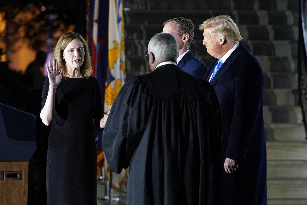 President Donald Trump watches as Supreme Court Justice Clarence Thomas administers the Constitutional Oath to Amy Coney Barrett on the South Lawn of the White House in Washington, Monday, Oct. 26, 2020, after Barrett was confirmed by the Senate earlier in the evening. (AP Photo / Patrick Semansky)