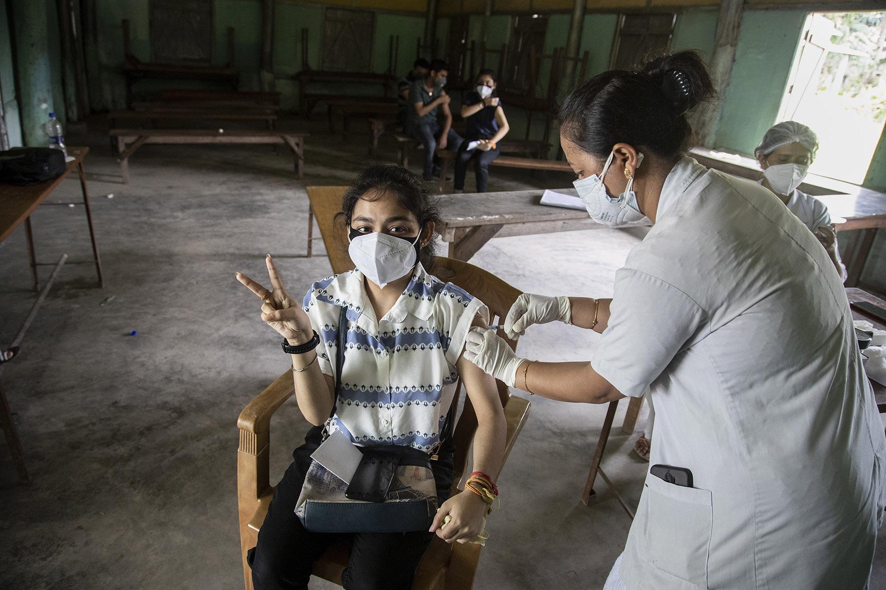 An Indian woman getting vaccinated with a dose of COVAXIN against the coronavirus gestures to camera in Gauhati, Assam, India, Monday, May 10, 2021. (AP Photo / Anupam Nath)