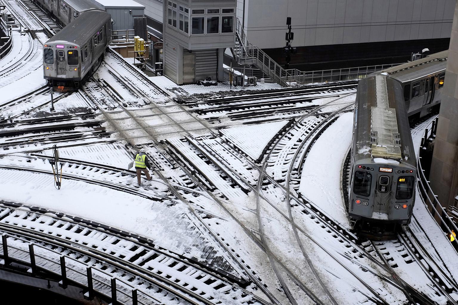 CTA trains move along snow-covered tracks Monday, Jan. 28, 2019, in Chicago. (AP Photo / Kiichiro Sato)